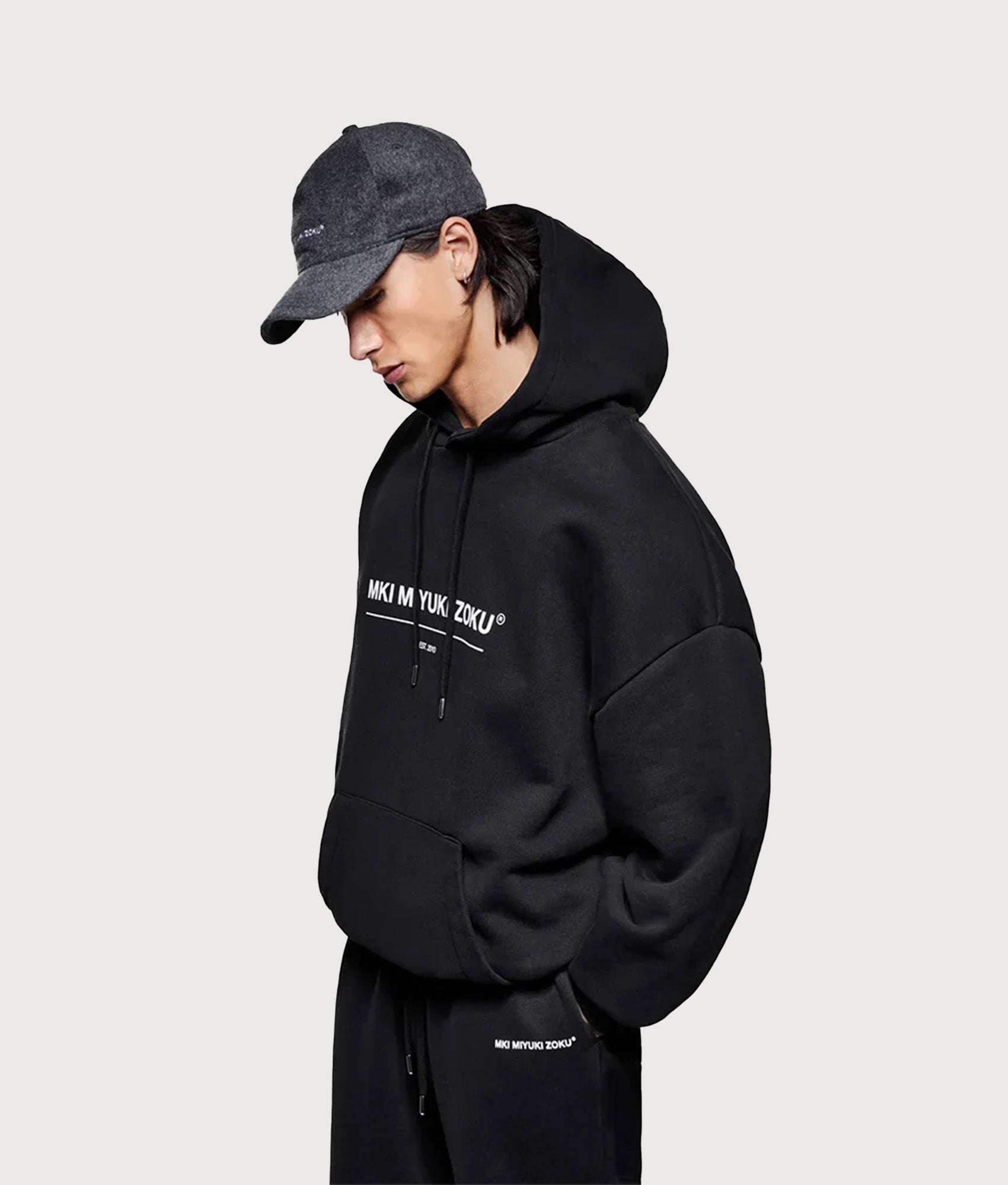 MKI MIYUKI ZOKU Oversized Linear Hoodie in Black at EQVVS Menswear.  Angled model front shot.