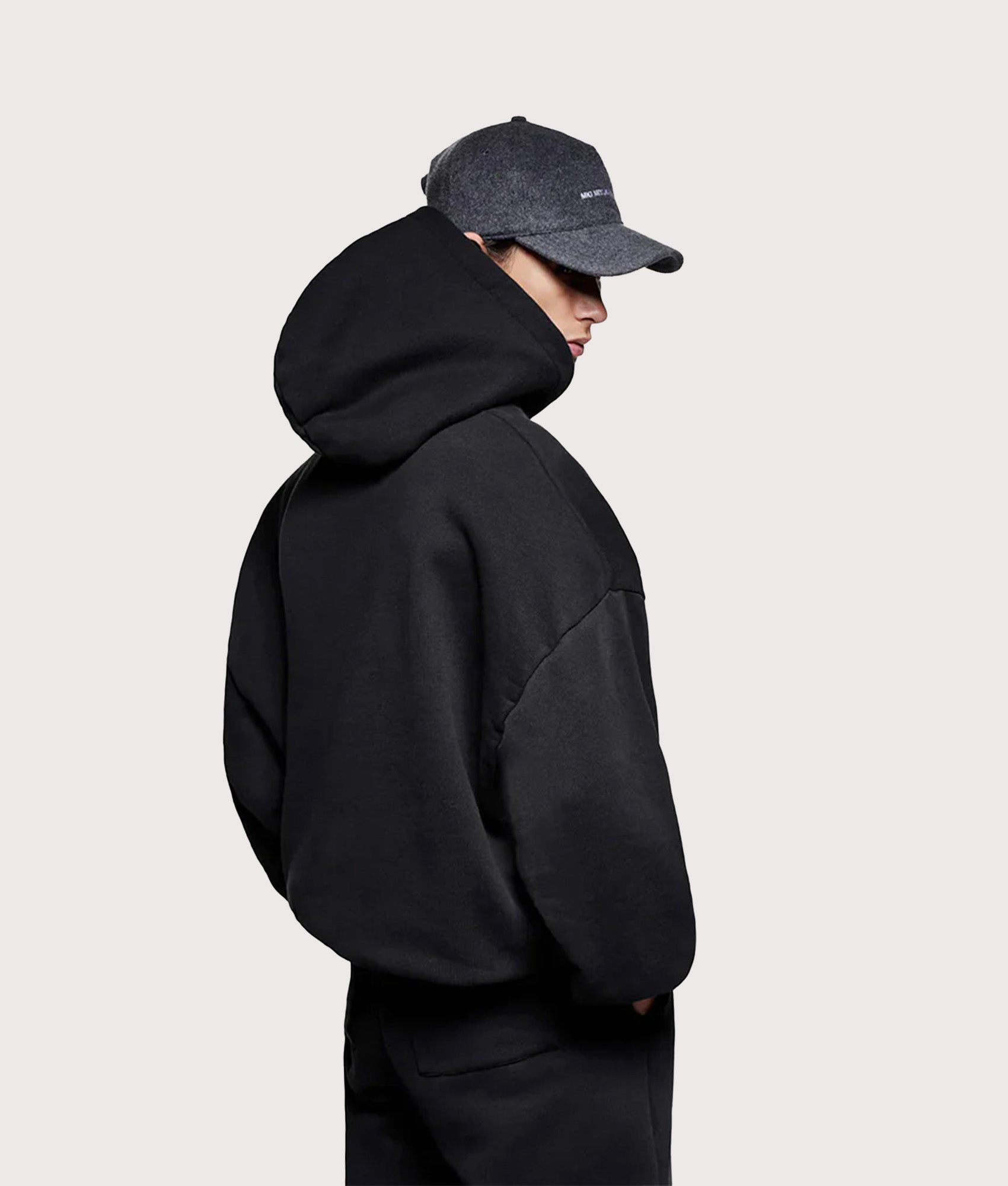 MKI MIYUKI ZOKU Oversized Linear Hoodie in Black at EQVVS Menswear. Angled model back shot.