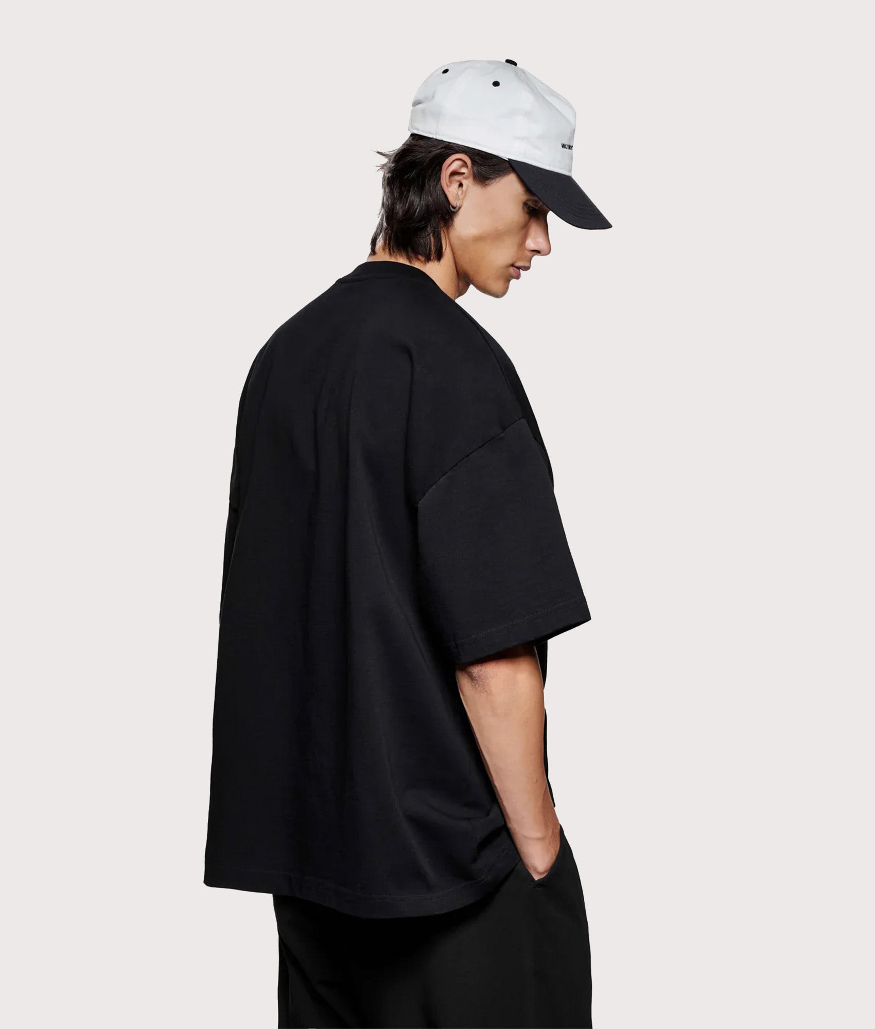 MKI MIYUKI ZOKU Oversized Linear T-Shirt in Black at EQVVS Menswear. Angled model back shot.