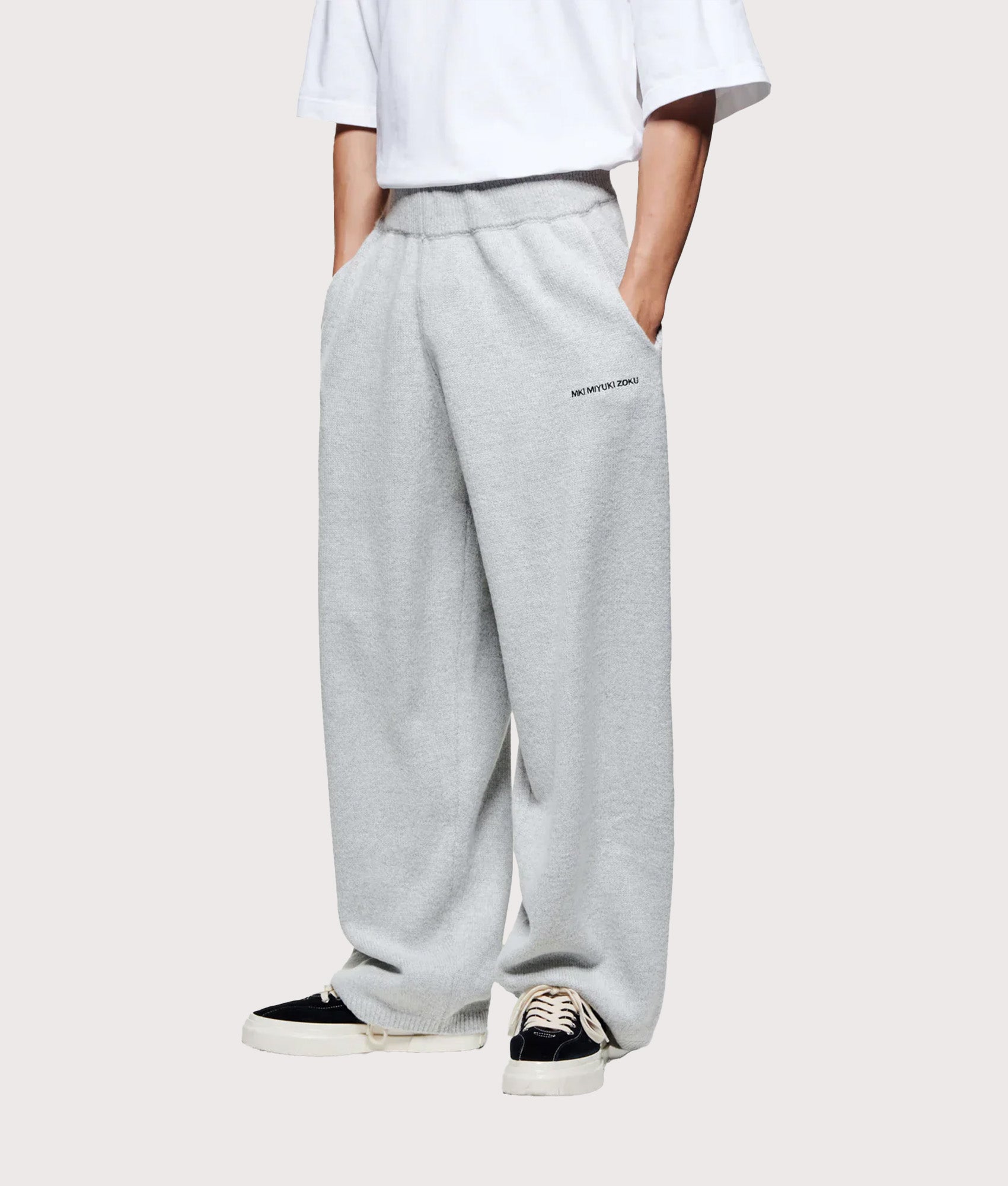 MKI MIYUKI ZOKU Relaxed Fit Mohair Blend Knit Wide Leg Joggers in Light Grey at EQVVS Menswear. Angled model front shot.
