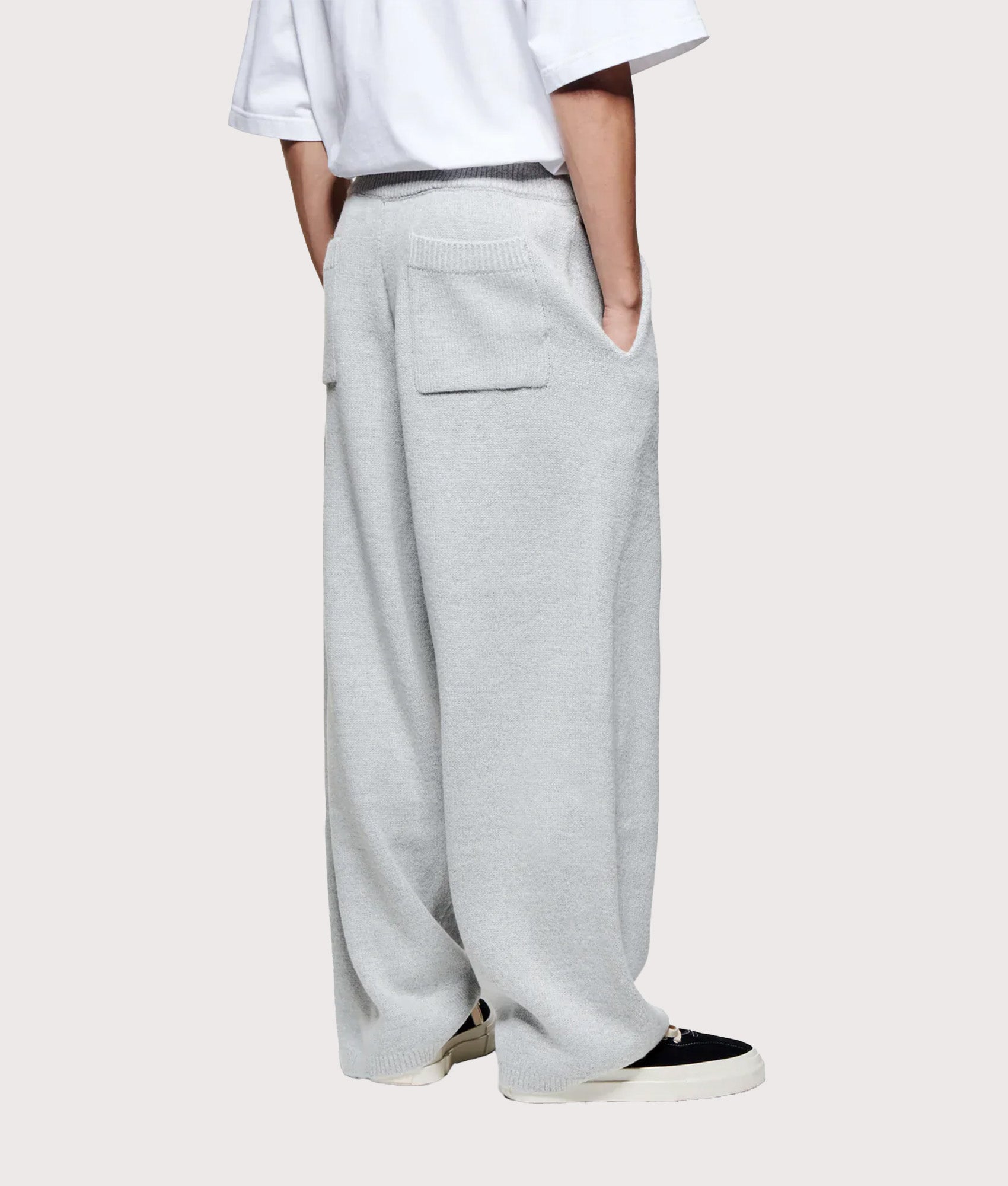 MKI MIYUKI ZOKU Relaxed Fit Mohair Blend Knit Wide Leg Joggers in Light Grey at EQVVS Menswear. Model back shot.