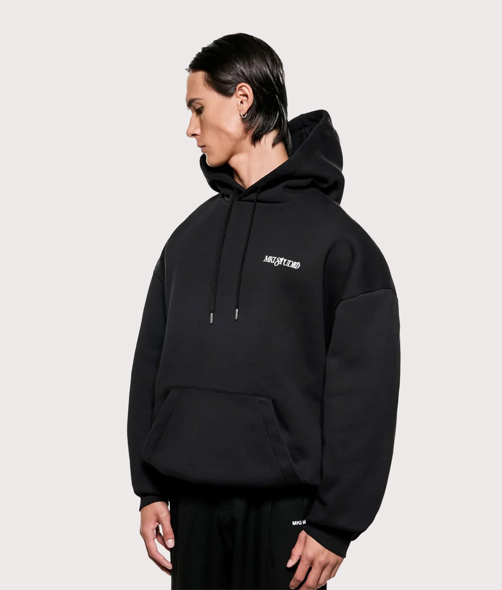 MKI MIYUKI ZOKU Script hoodie in Black at EQVVS Menswear. Angled model front shot.
