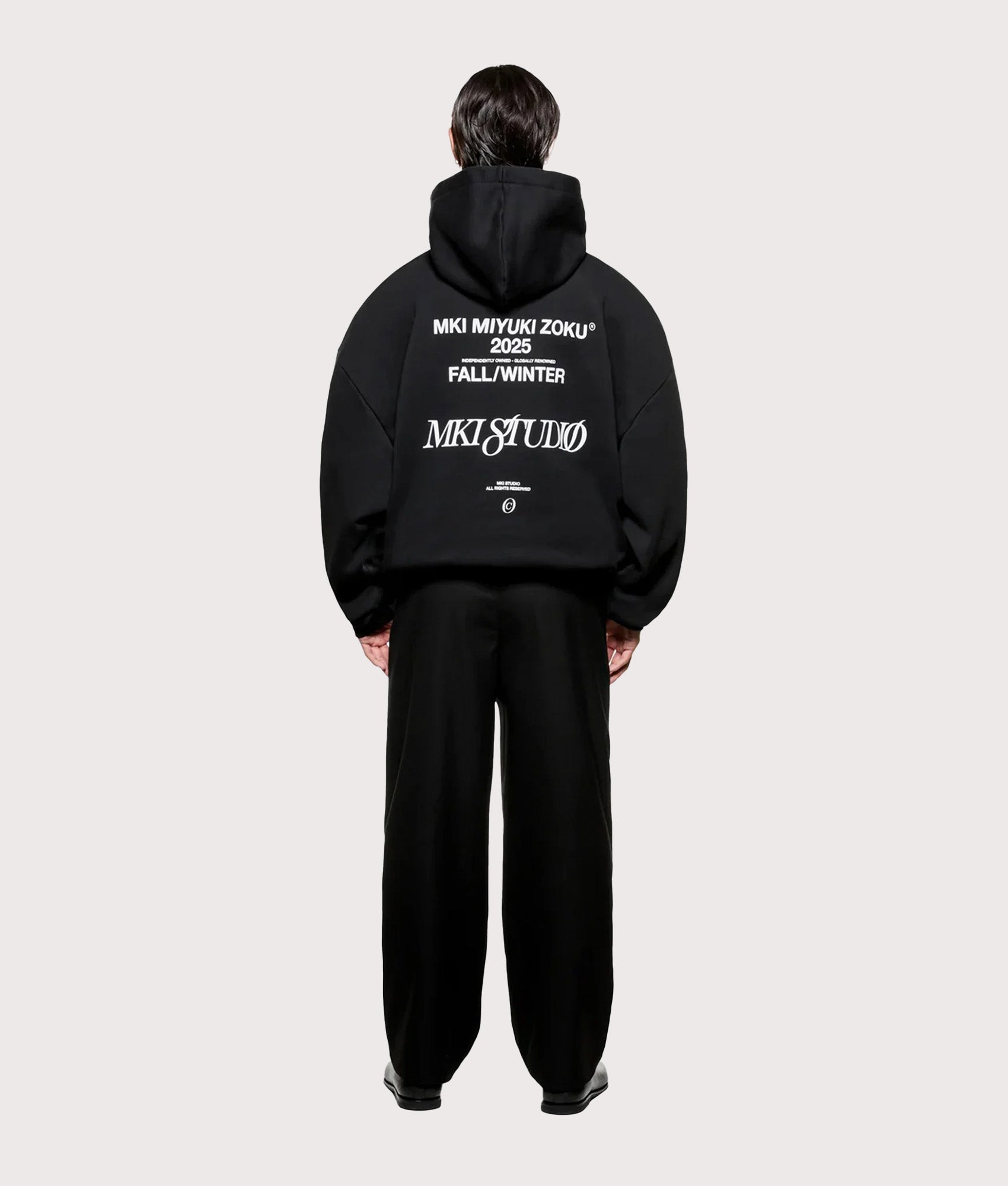 MKI MIYUKI ZOKU Script hoodie in Black at EQVVS Menswear. Model full back shot.