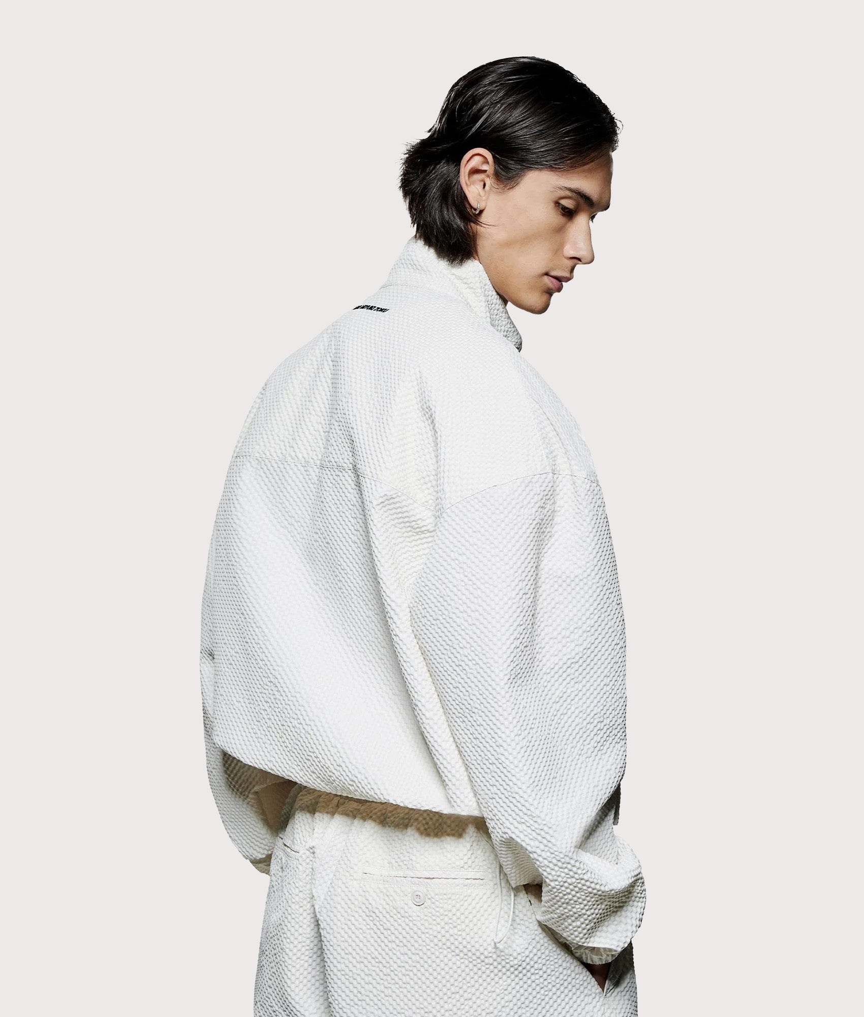 MKI MIYUKI ZOKU Seersucker Quarter Zip Sweatshirt in Bone at EQVVS Menswear. Model back shot.