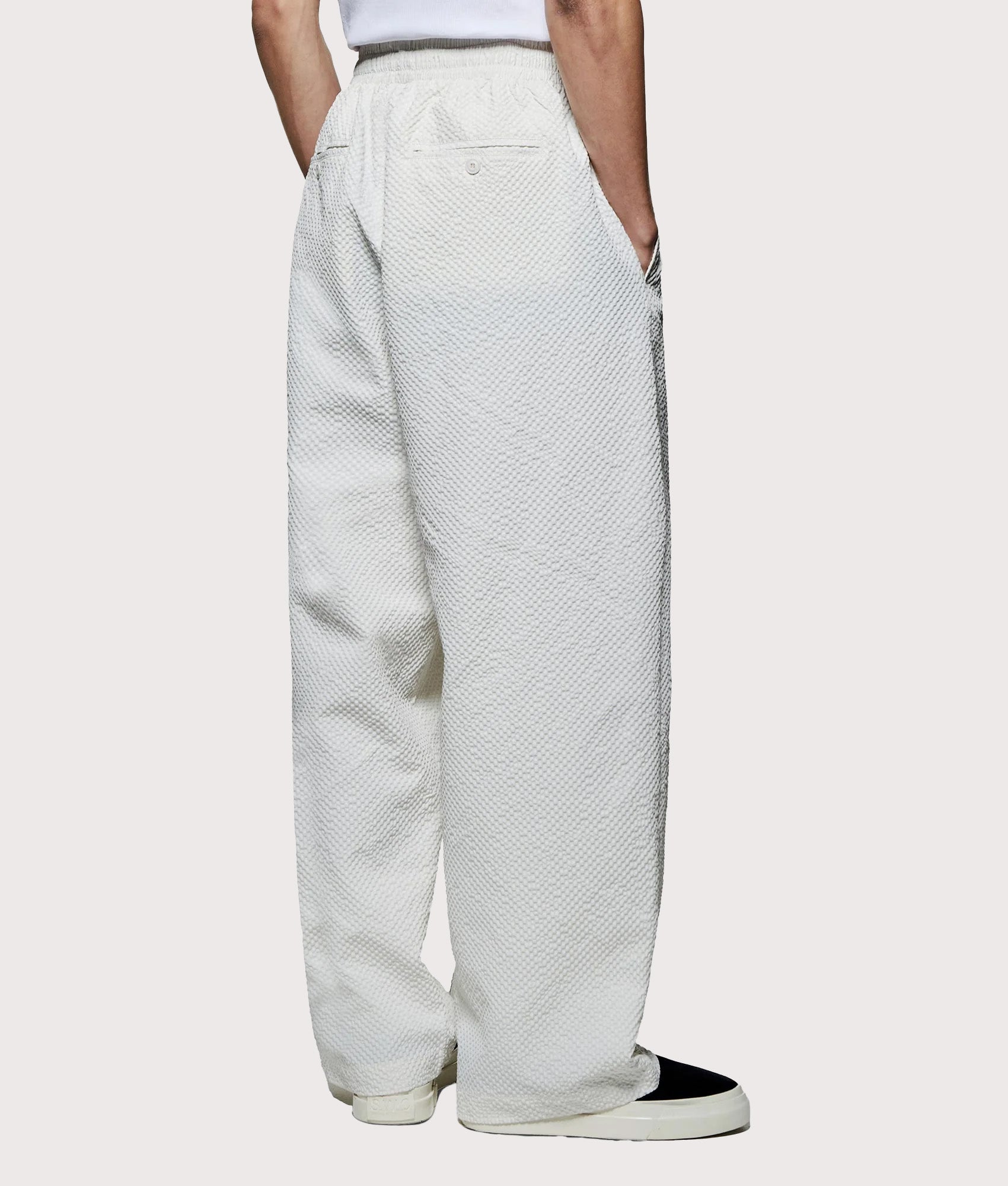MKI MIYUKI ZOKU Seersucker Wide Leg Trousers in Bone at EQVVS menswear. Angled model back shot.