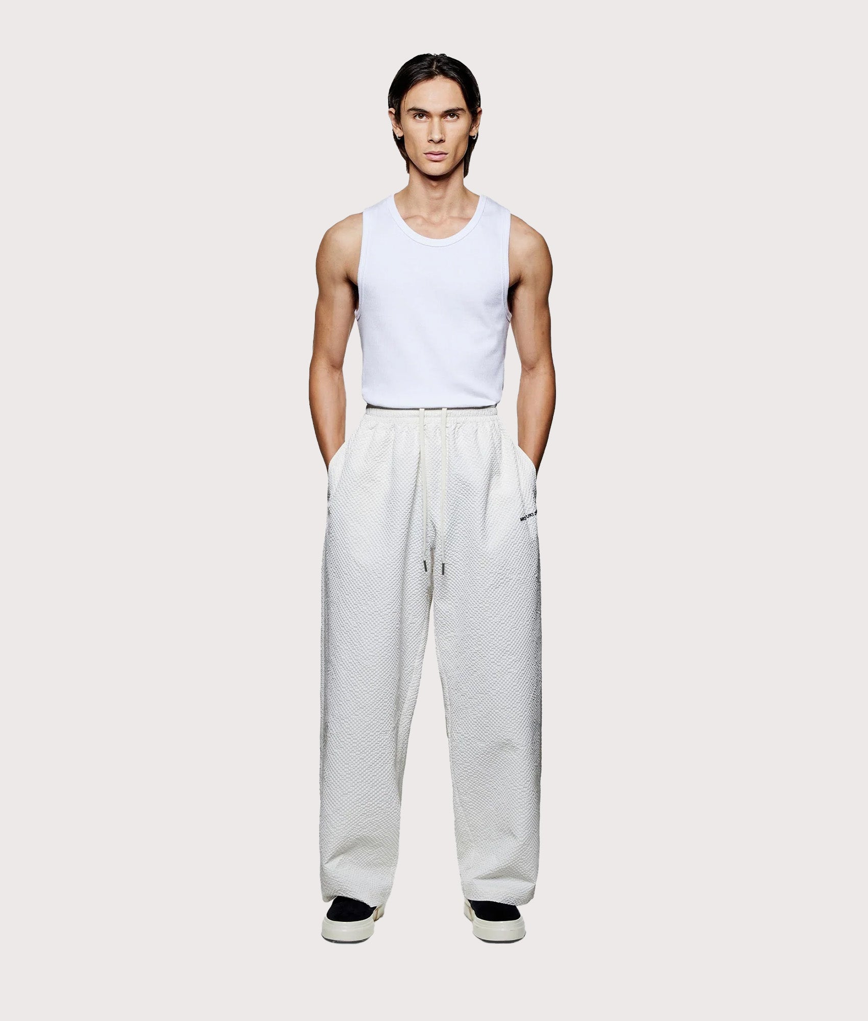 MKI MIYUKI ZOKU Seersucker Wide Leg Trousers in Bone at EQVVS menswear. Model full front shot.