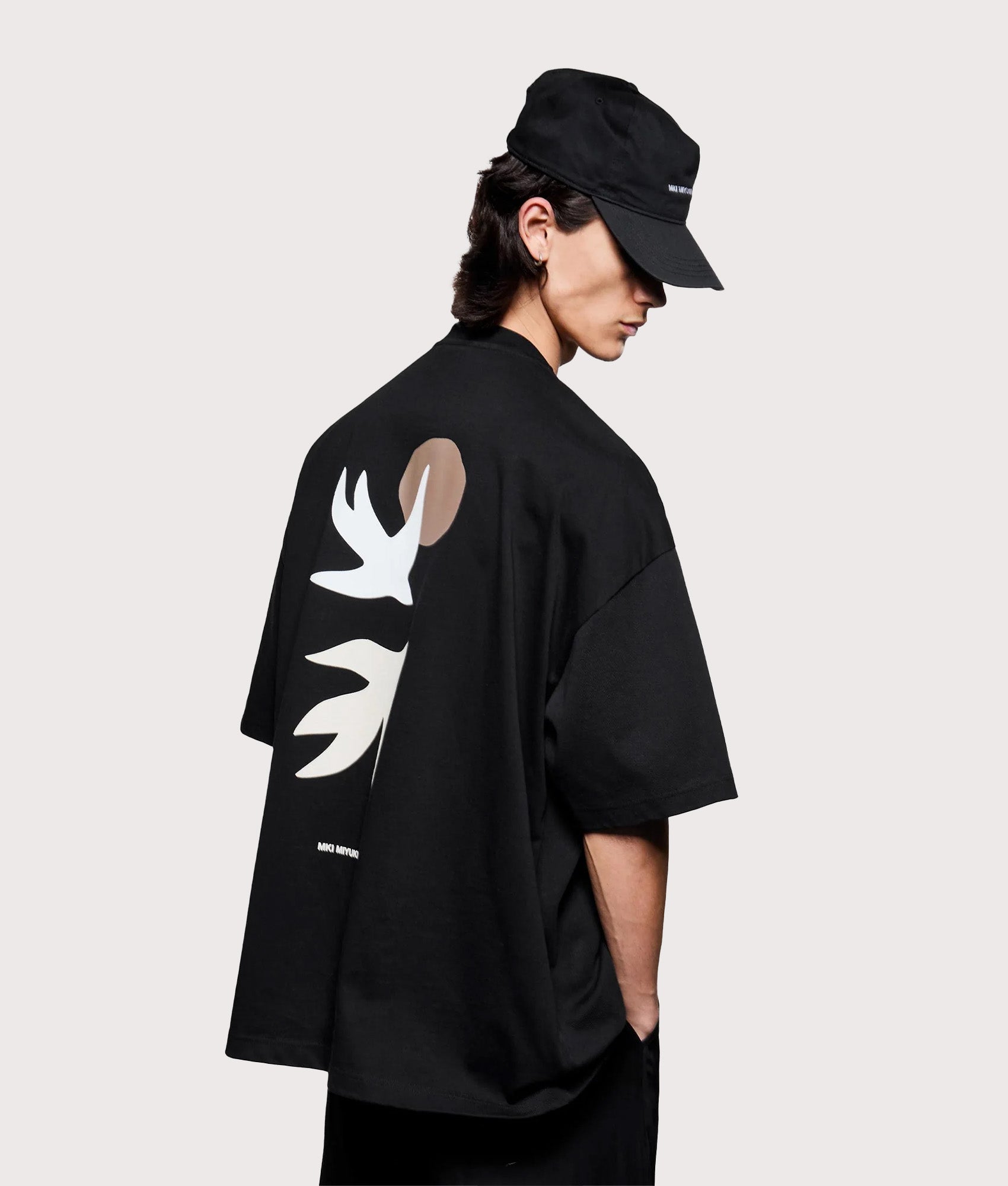 MKI MIYUKI ZOKU Oversized Swallow T-Shirt in Black at EQVVS Menswear. Angled model back shot.