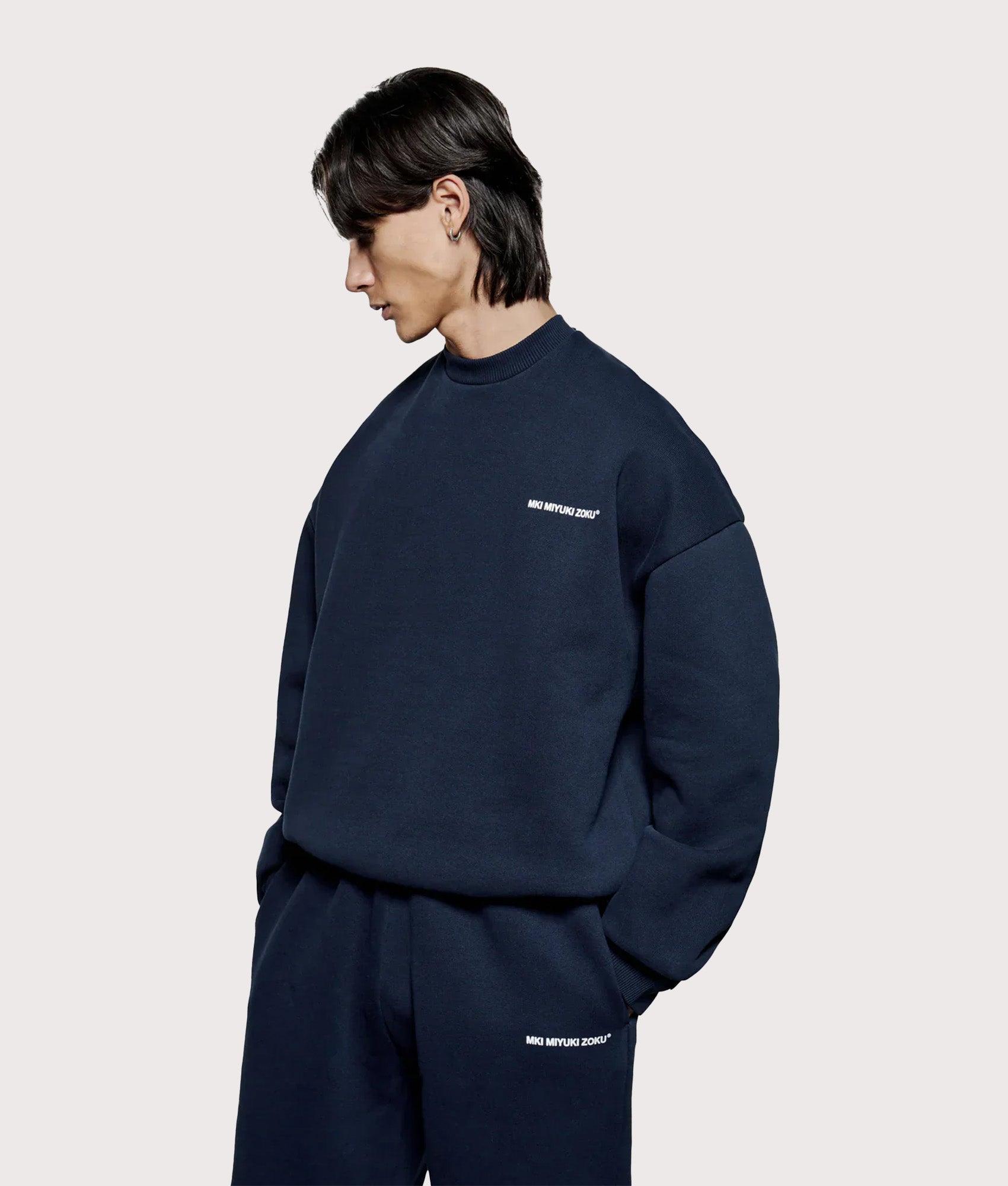 MKI MIYUKI ZOKU Oversized Uniform Crew Sweatshirt in Navy at EQVVS Menswear. Angled model front shot.