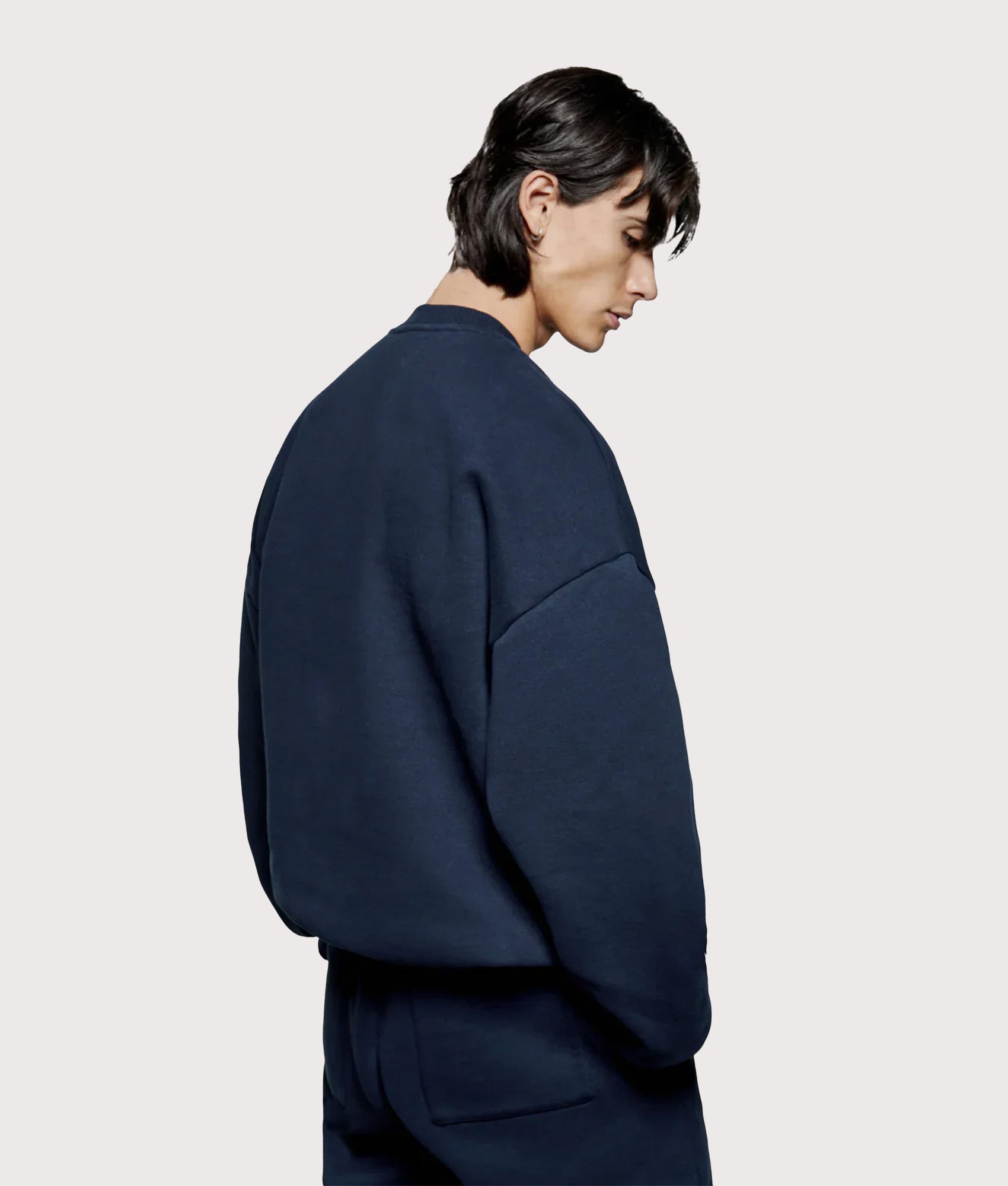 MKI MIYUKI ZOKU Oversized Uniform Crew Sweatshirt in Navy at EQVVS Menswear. Angled model back shot.