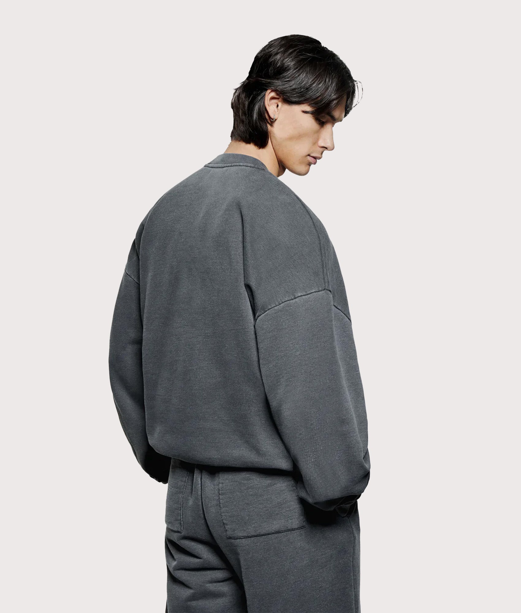 MKI Miyuki Zoku oversized Uniform Crew Sweatshirt in Pigment Black at EQVVS Menswear. Angled model back shot.