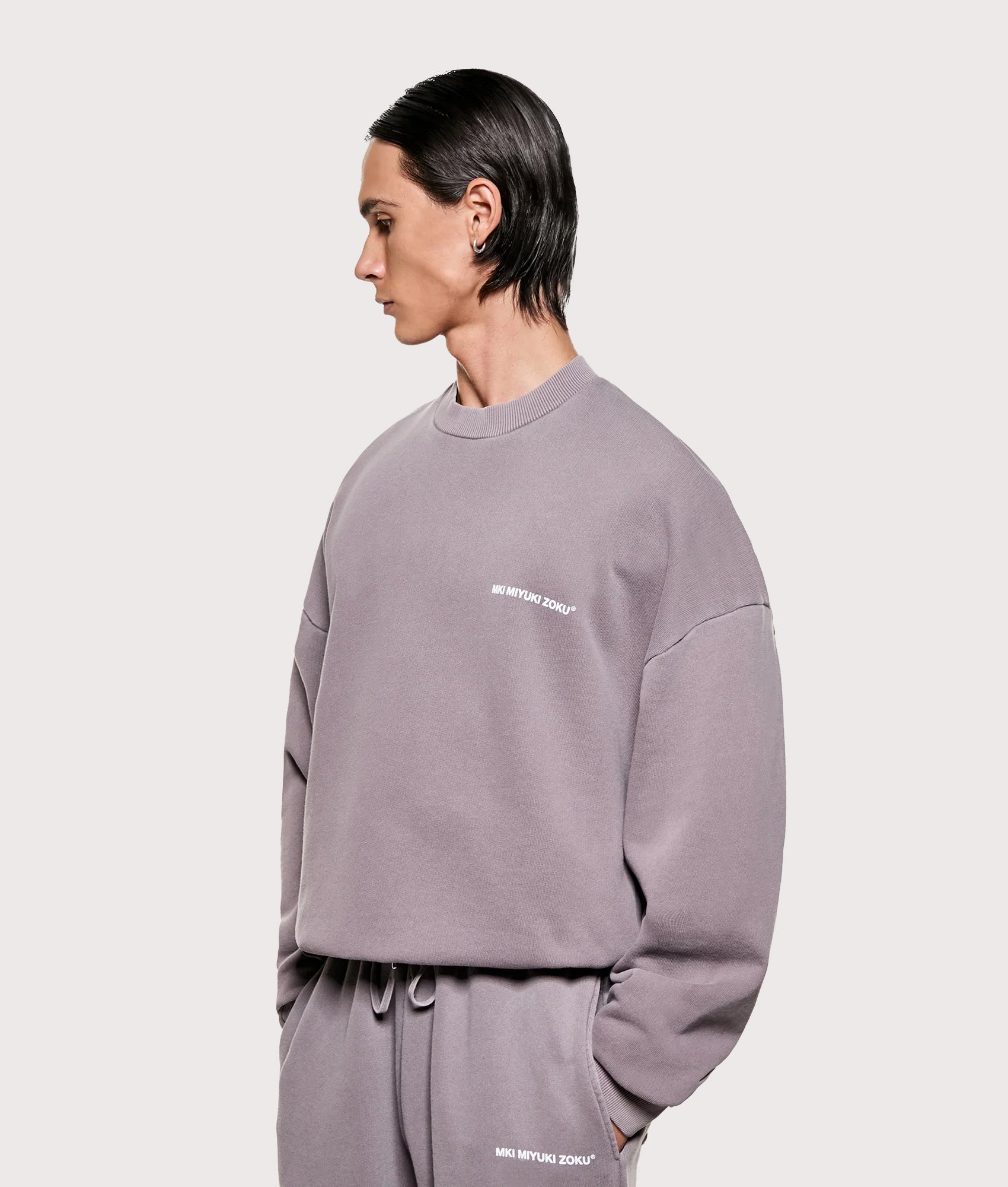 MKI MIYUKI ZOKU Oversized Uniform Crewneck Sweatshirt in Pigment Raisin at EQVVS Menswear. Angled model front shot.