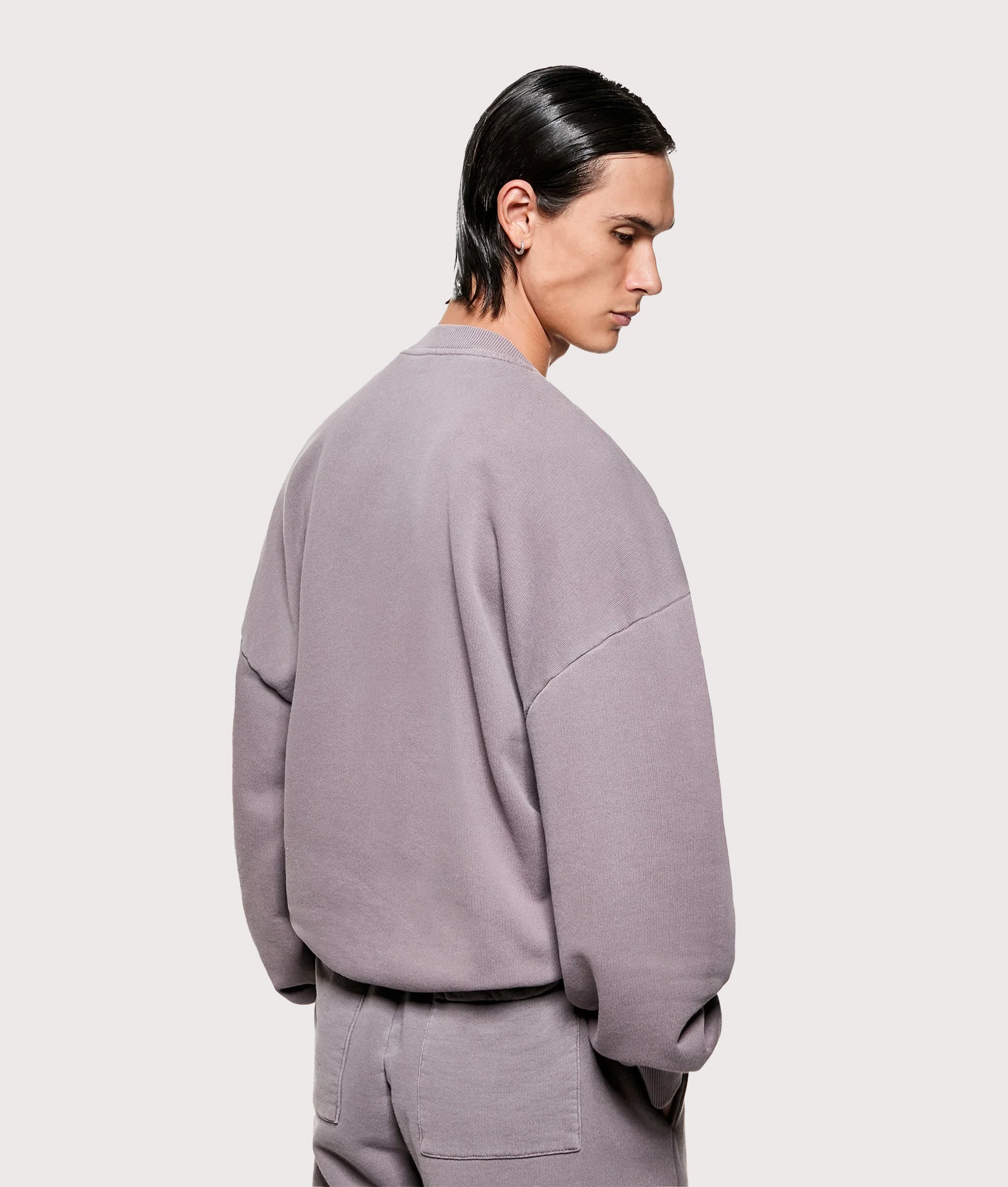 MKI MIYUKI ZOKU Oversized Uniform Crewneck Sweatshirt in Pigment Raisin at EQVVS Menswear. Angled model back shot.