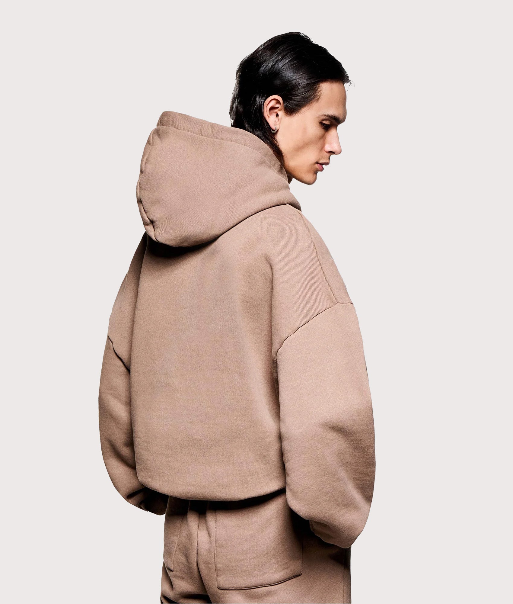 MKI MIYUKI ZOKU Oversized Uniform Hoodie in Mushroom at EQVVS Menswear. Angled model back shot.