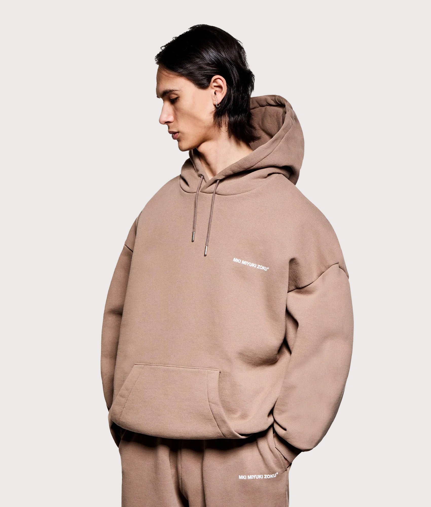 MKI MIYUKI ZOKU Oversized Uniform Hoodie in Mushroom at EQVVS Menswear. Angled model front shot.