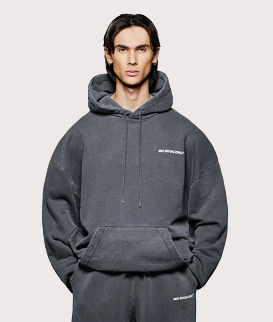 MKI Miyuki Zoku Oversized Uniform Hoodie in Pigment Black at EQVVS Menswear. Full model front shot.