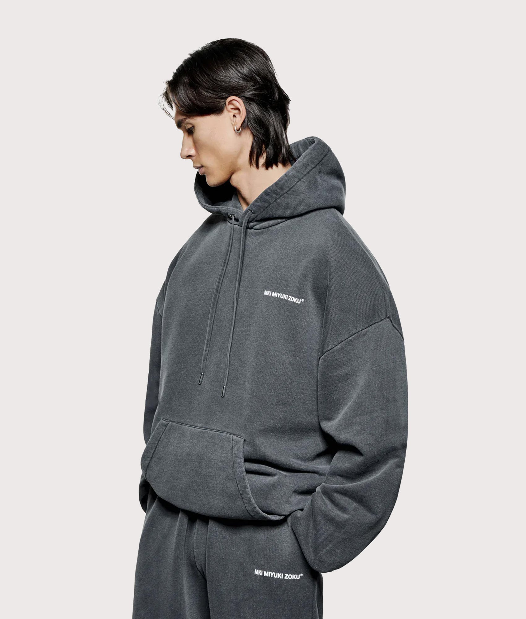 MKI Miyuki Zoku Oversized Uniform Hoodie in Pigment Black at EQVVS Menswear. Angled model front shot.