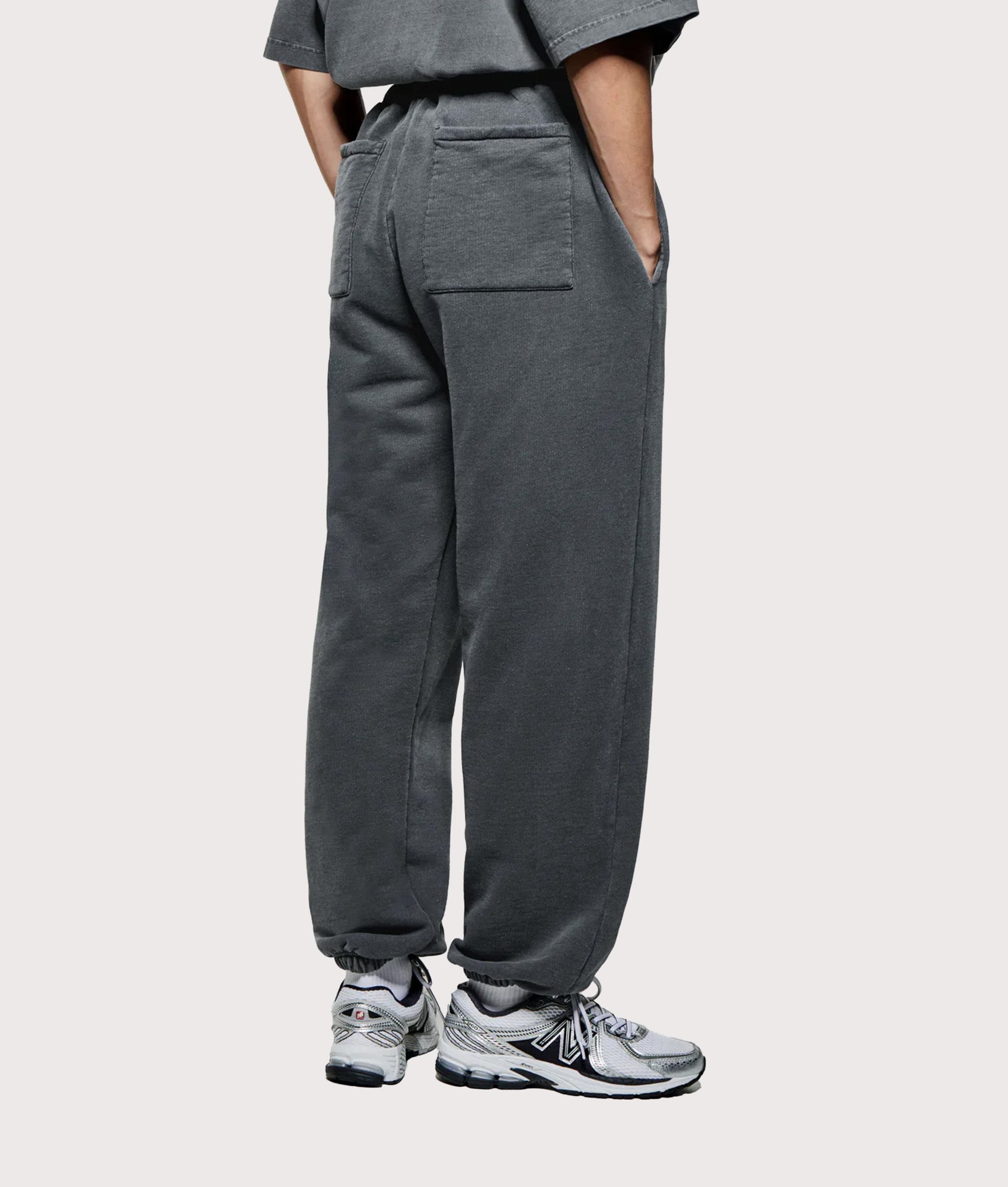 MKI Miyuki Zoku Uniform Joggers in PIgment Black at EQVVS Menswear. Angled model back shot.