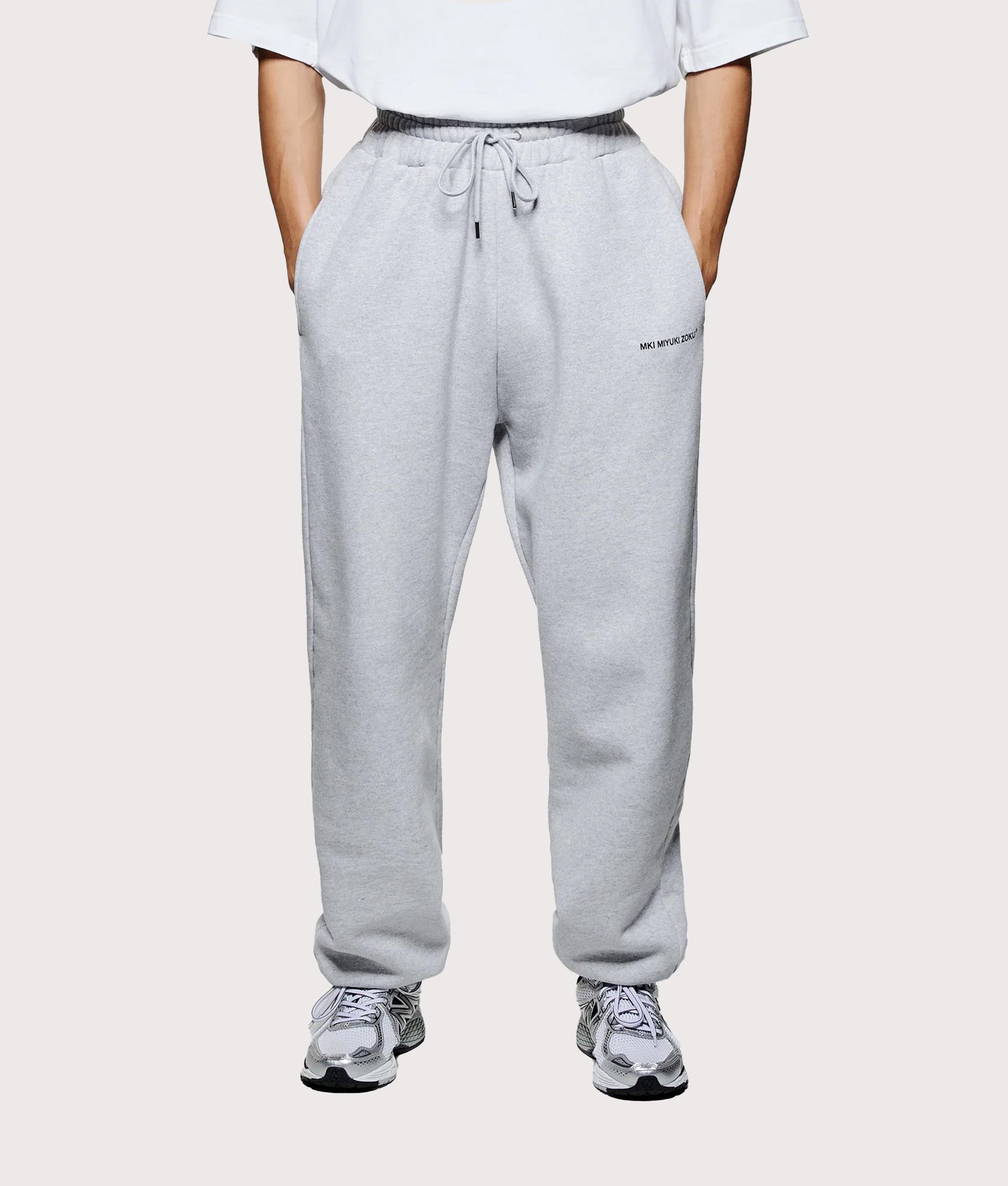 MKI MIYUKI ZOKU Uniform Joggers in Grey at EQVVS Menswear. Model front shot.