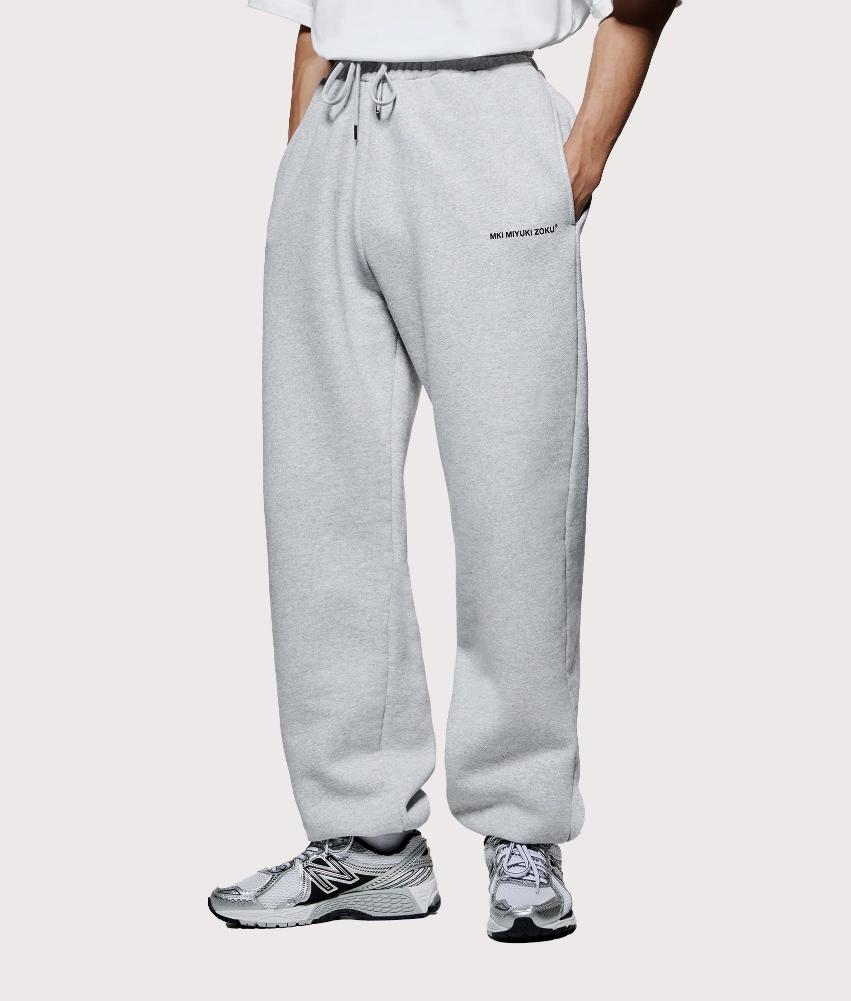 MKI MIYUKI ZOKU Uniform Joggers in Grey at EQVVS Menswear. Angled model front shot.