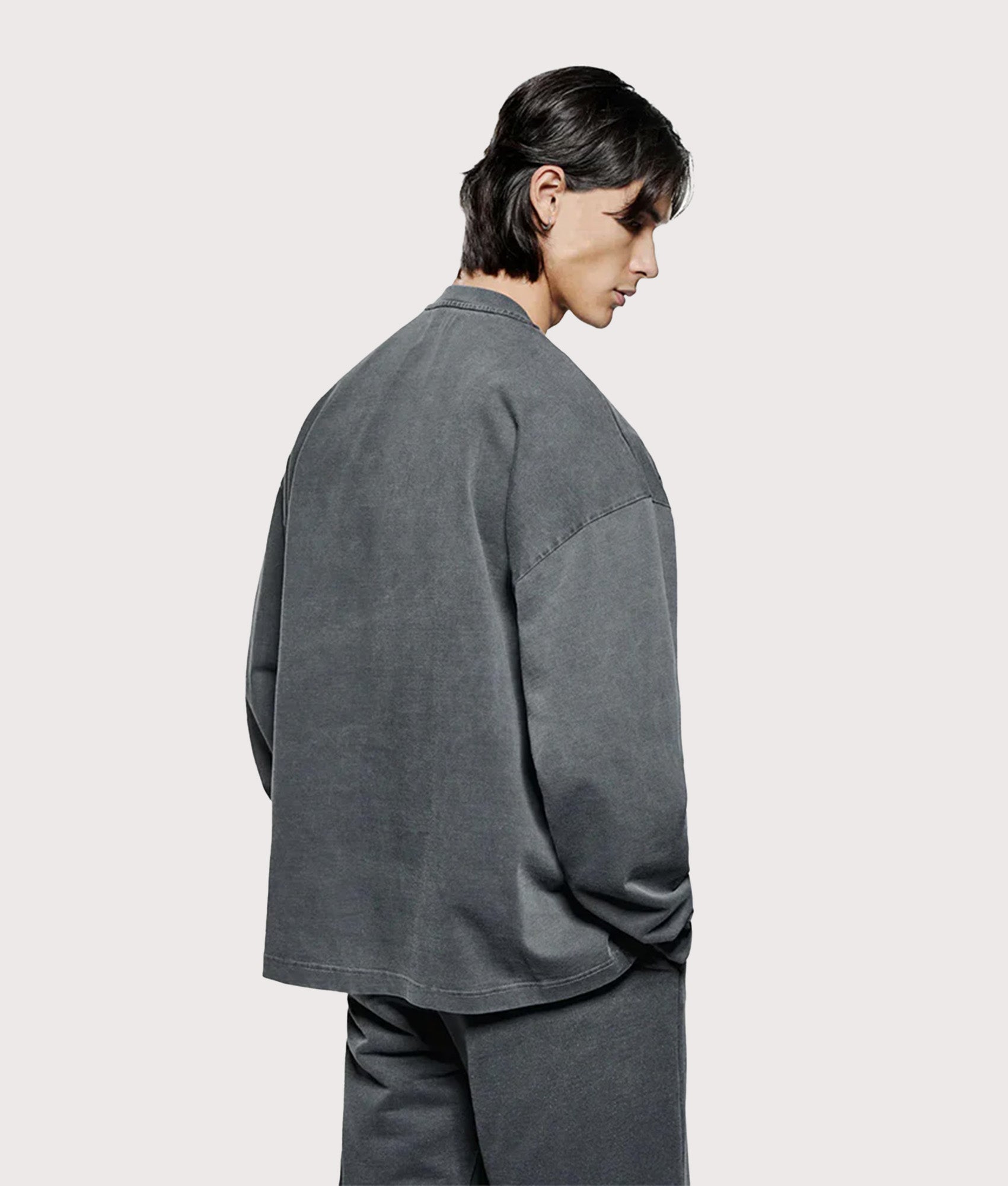 MKI Miyuki Zoku Long Sleeve Uniform T-Shirt in Pigment Black at EQVVS Menswear. Angled model back shot.