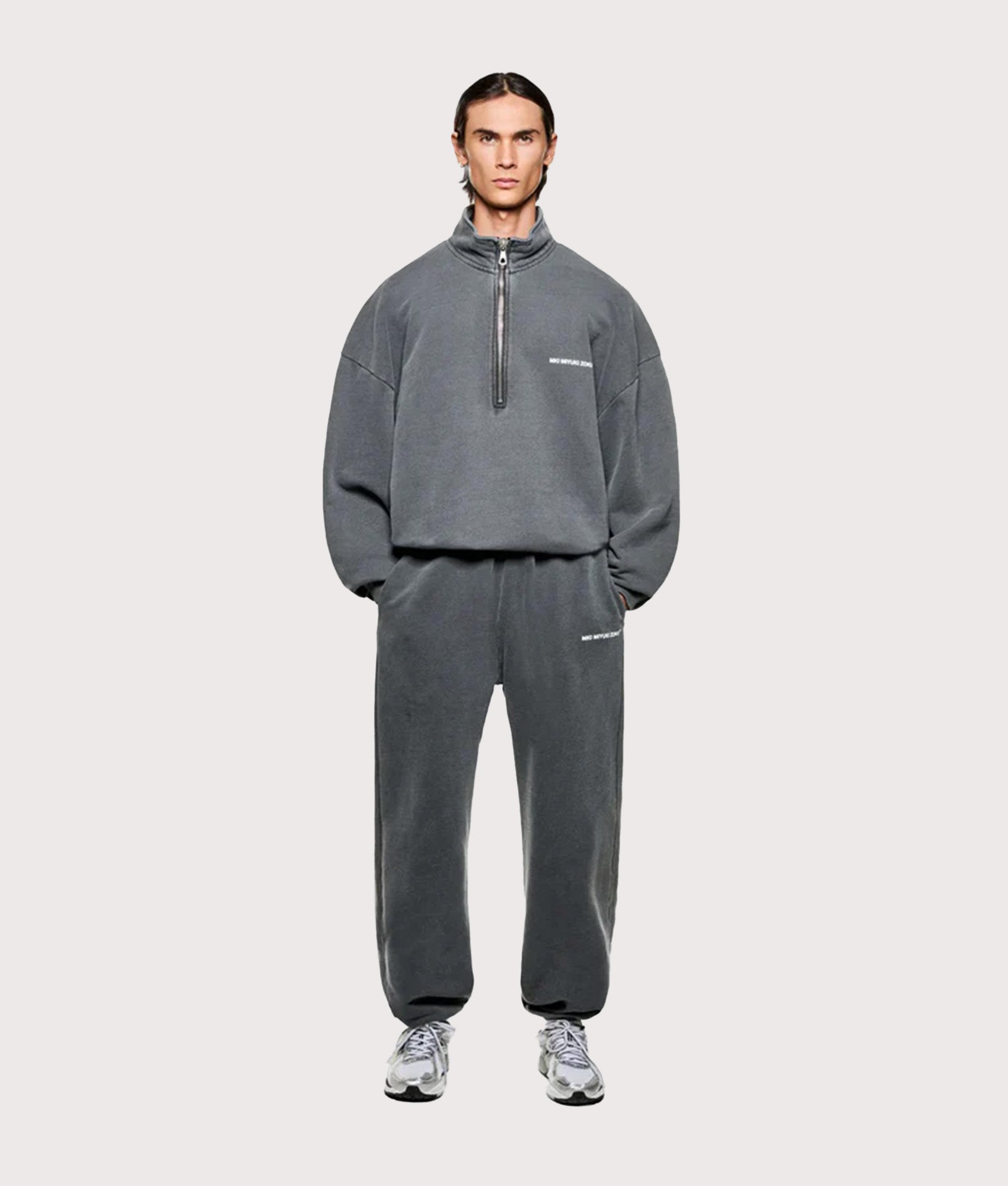 MKI MIYUKI ZOKU Oversized Uniform Quarter Zip Sweatshirt in Pigment Black at EQVVS Menswear. Model full front shot.