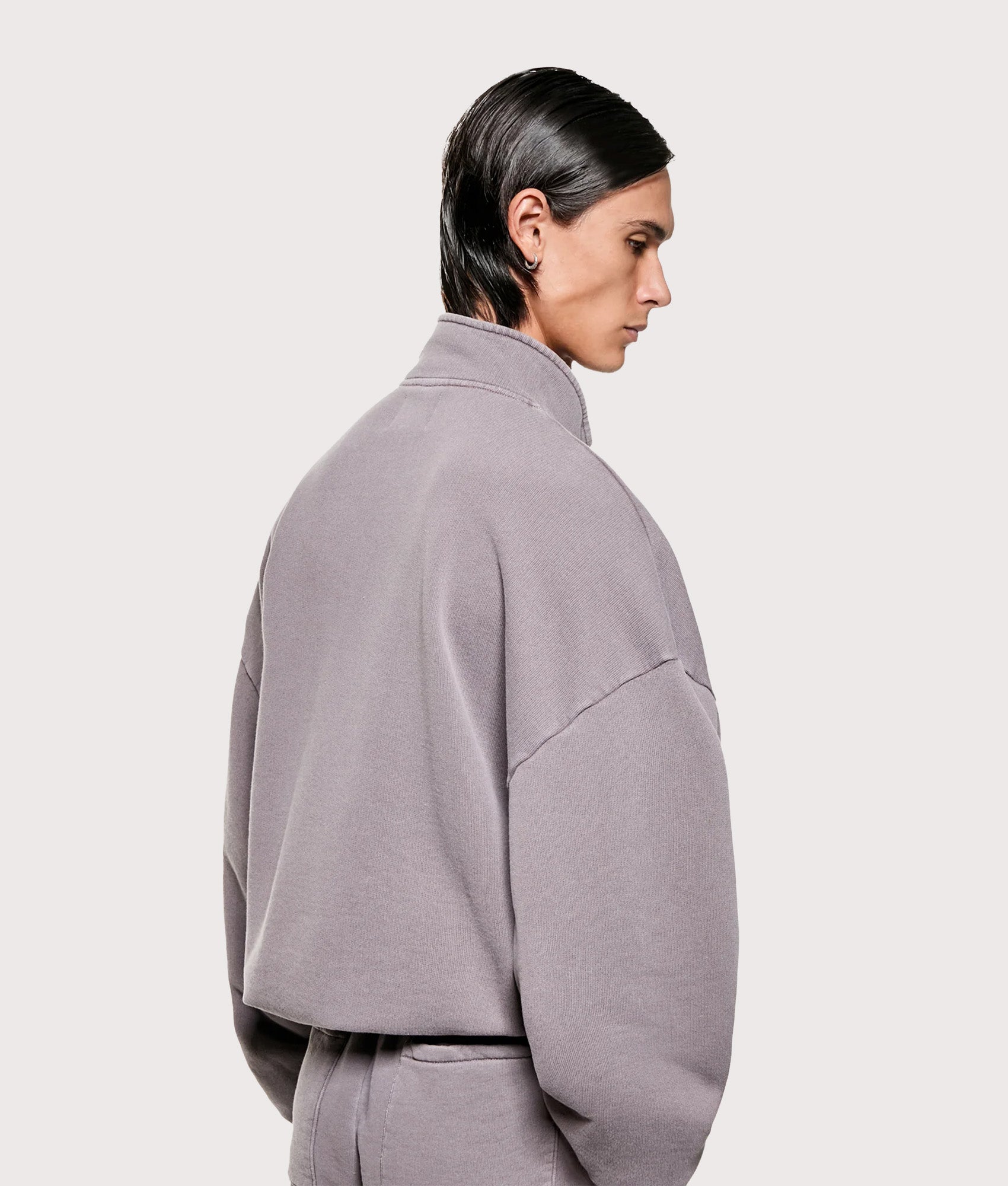 MKI MIYUKI ZOKU Oversized Fit MKI Uniform Quarter Zip in Pigment Raisin at EQVVS Menswear. Angled model back shot.