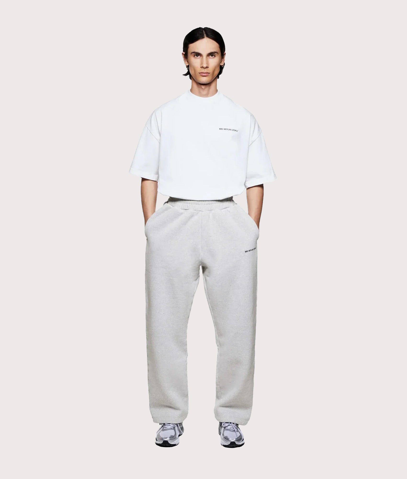 MKI MIYUKI ZOKU Uniform Wide Leg Joggers in grey at EQVVS Menswear. Model full front shot.