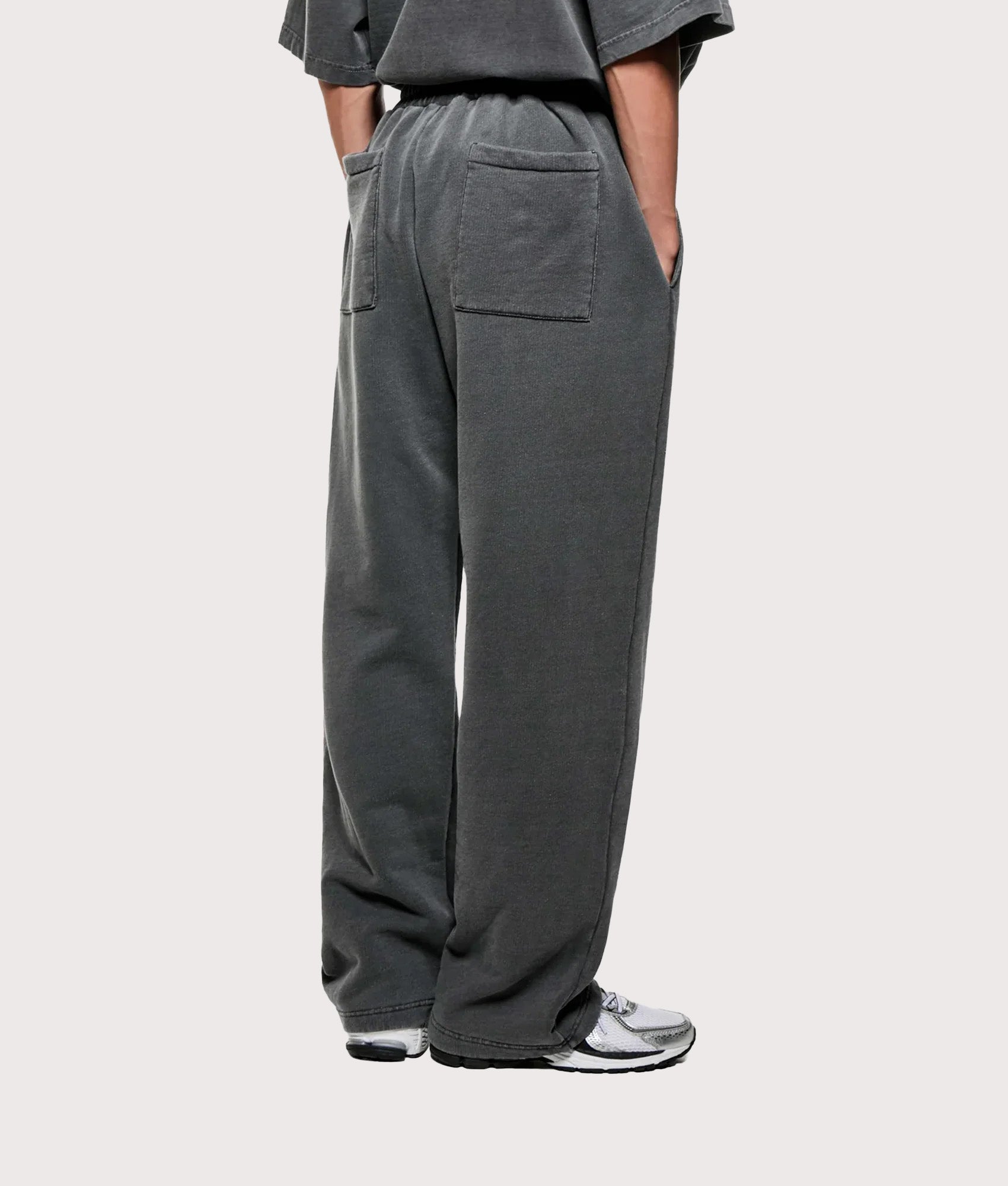 MKI MIYUKI ZOKU Uniform Wide Leg Joggers arrive in the Pigment Black at EQVVS Menswear. Angled model back shot.
