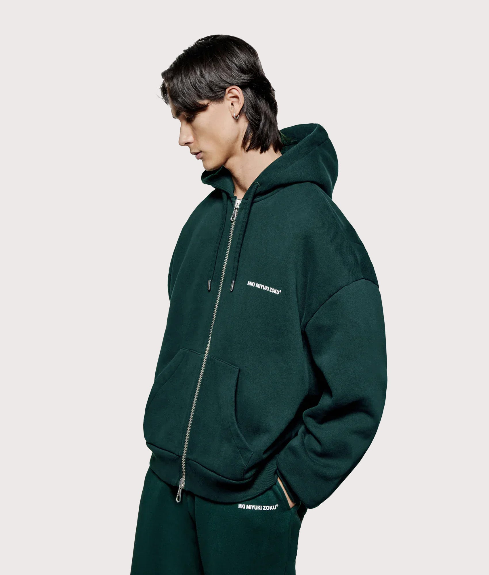 MKI MIYUKI ZOKU Oversized Uniform Zip Through Hoodie in Green at EQVVS Menswear. Angled model front shot.