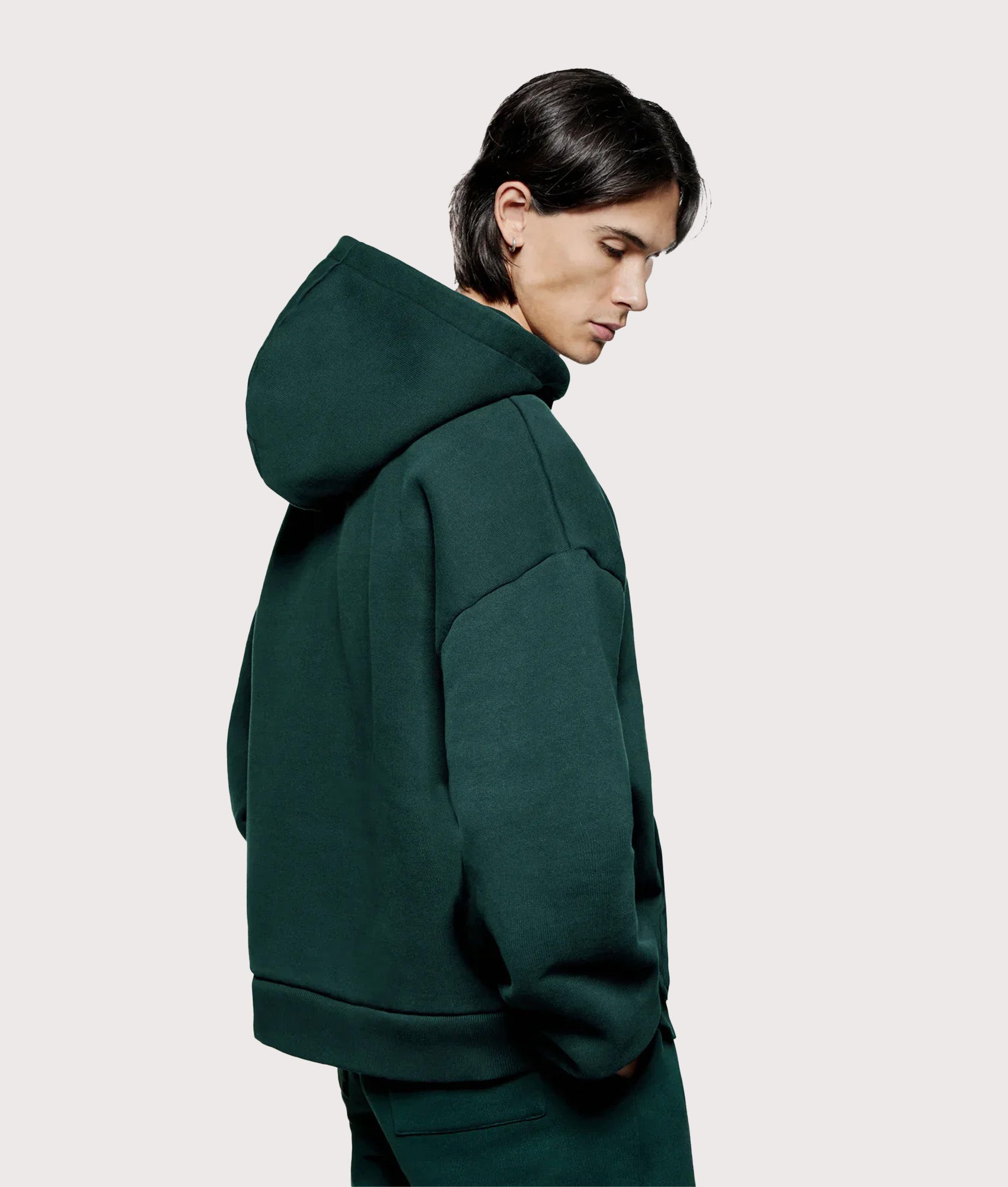 MKI MIYUKI ZOKU Oversized Uniform Zip Through Hoodie in Green at EQVVS Menswear. Angled model back shot.