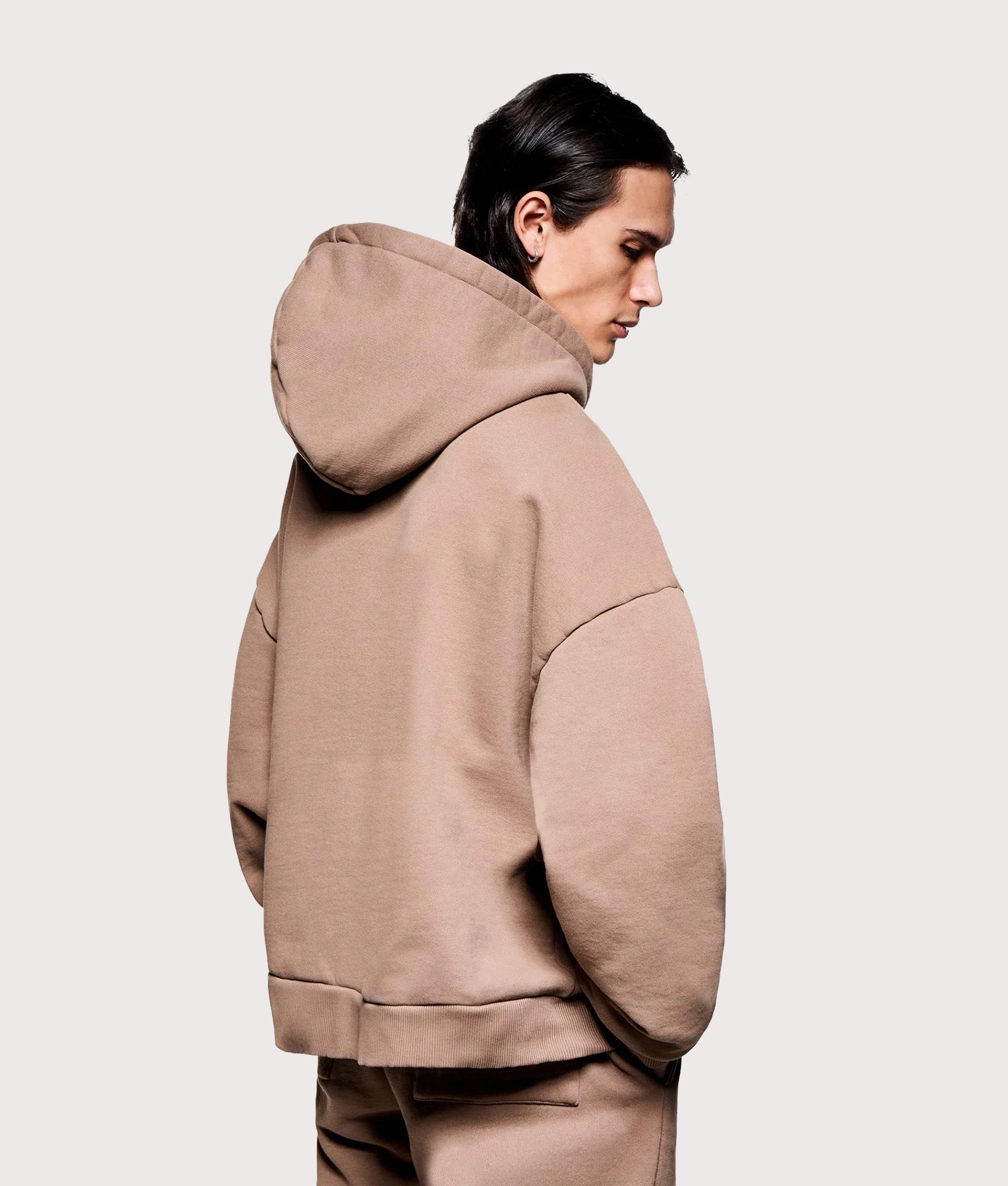 MKI MIYUKI ZOKU Oversized Uniform Zip Hoodie in Mushroom at EQVVS Menswear. Angled model back shot.