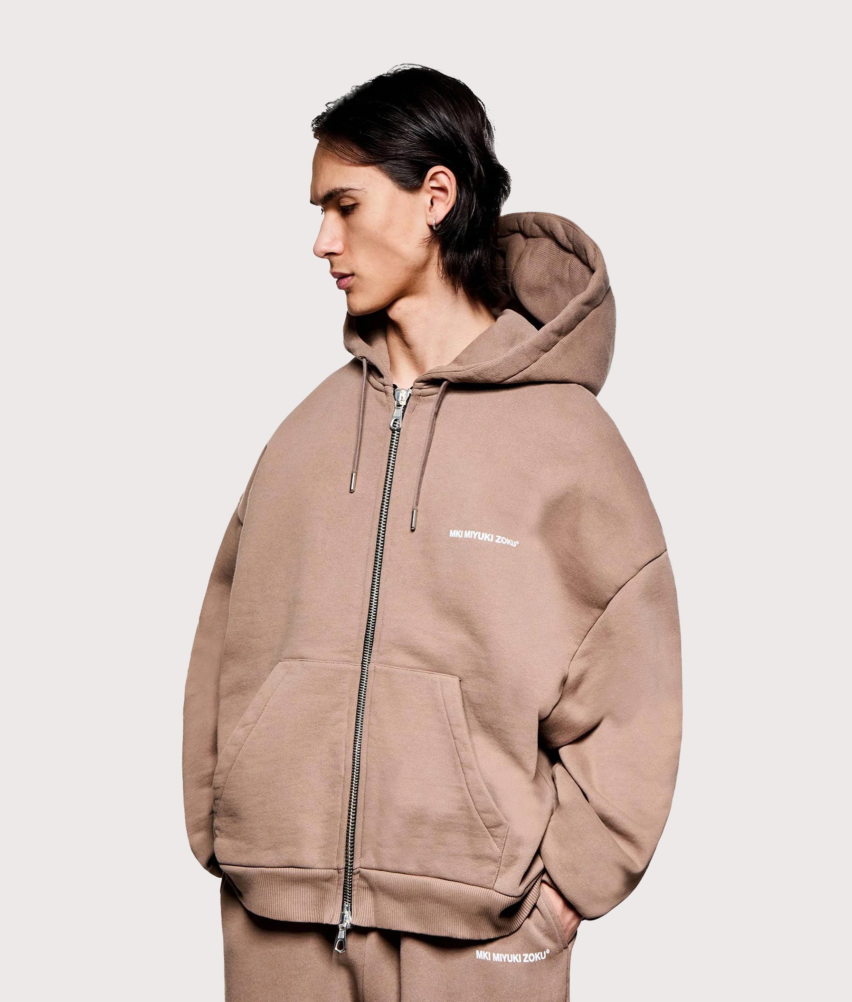 MKI MIYUKI ZOKU Oversized Uniform Zip Hoodie in Mushroom at EQVVS Menswear. Angled model front shot.
