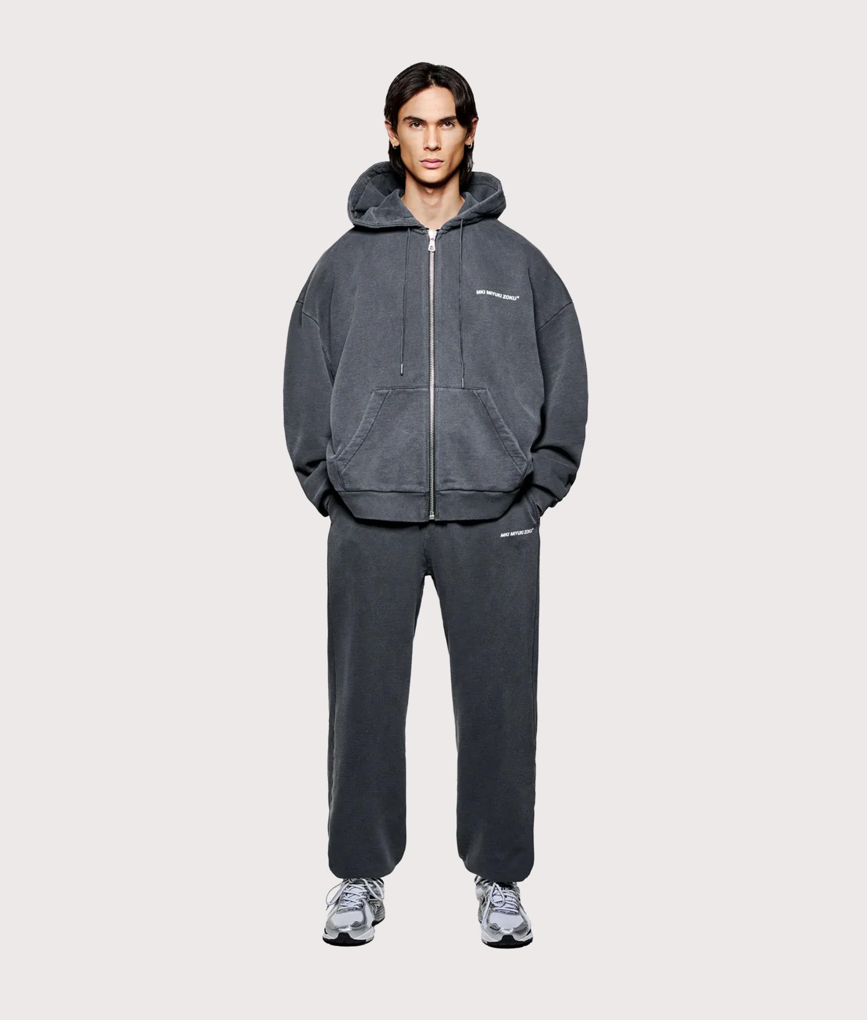 MKI MIYUKI ZOKU Oversized Uniform Zip Through Hoodie in Pigment Black at EQVVS Menswear. Model full front shot.