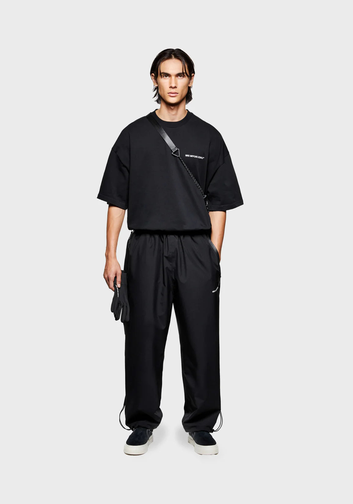 Loose Fit V2 Shell Track Pants in Black by MKI MIYUKI ZOKU at EQVVS. Front Model Shot. 