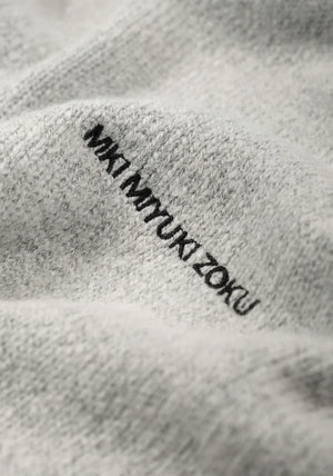 MKI MIYUKI ZOKU Mohair Blend Knit Hoodie in Light Grey at EQVVS Menswear. Detail Logo Shot.
