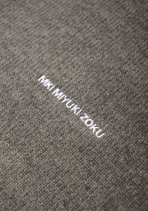MKI MIYUKI ZOKU Mohair Blend Knit Hoodie in Brown Marl at EQVVS Menswear. Detail Logo Shot. 