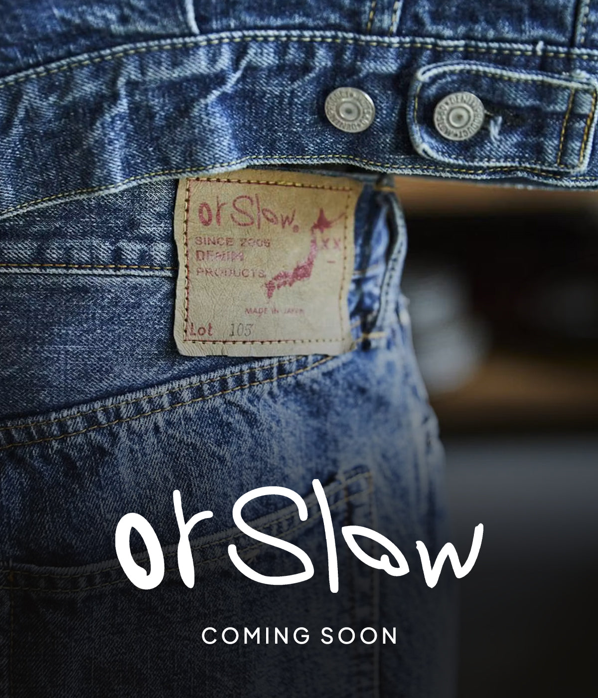 OrSlow denim jeans label on a close-up of blue denim, with the OrSlow logo and “Coming Soon” text on a dark, blurred background.