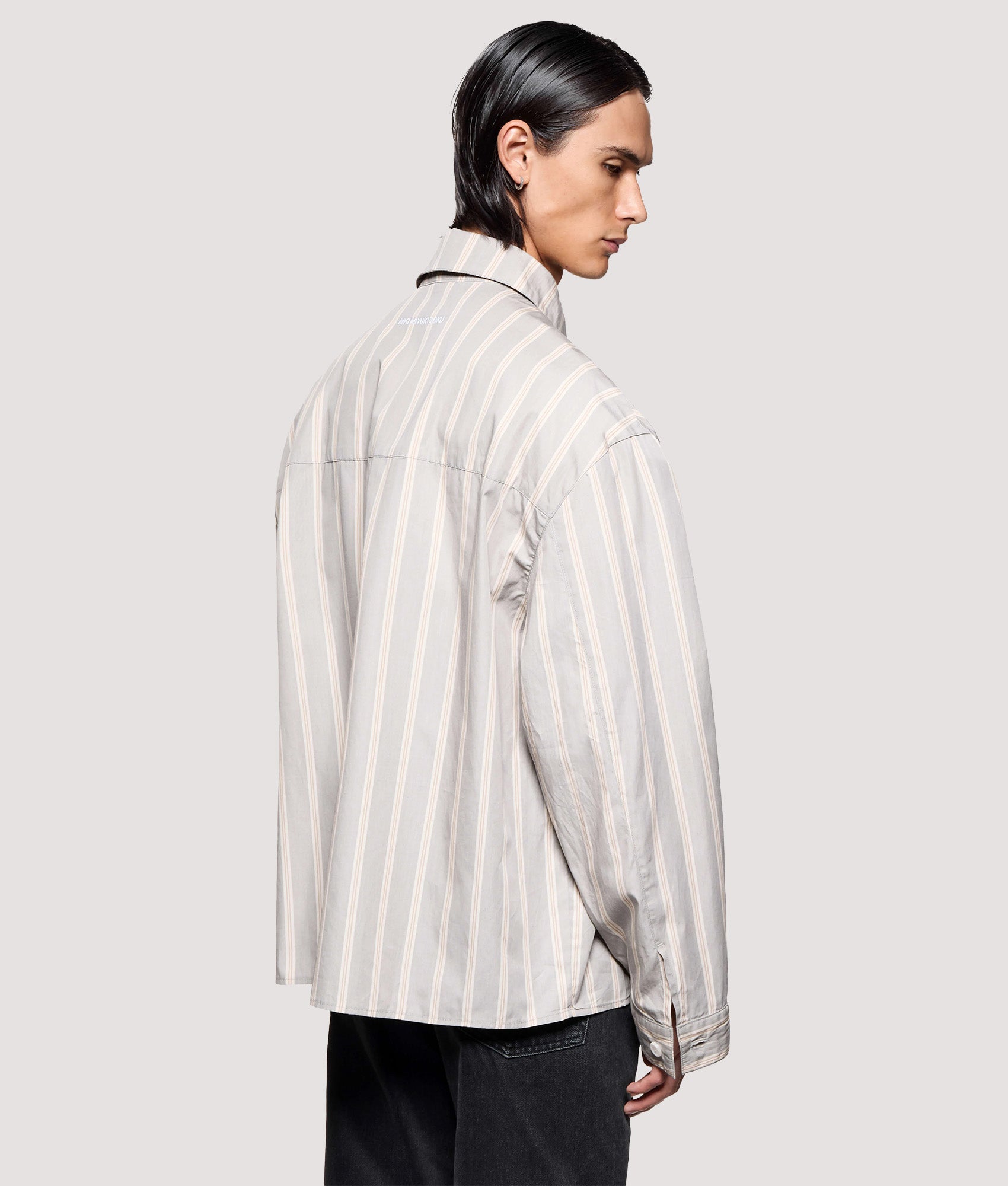 MKI MIYUKI ZOKU Box Fit Poplin Stripe Dress Shirt in Light Grey at EQVVS Menswear. Angled model back shot.