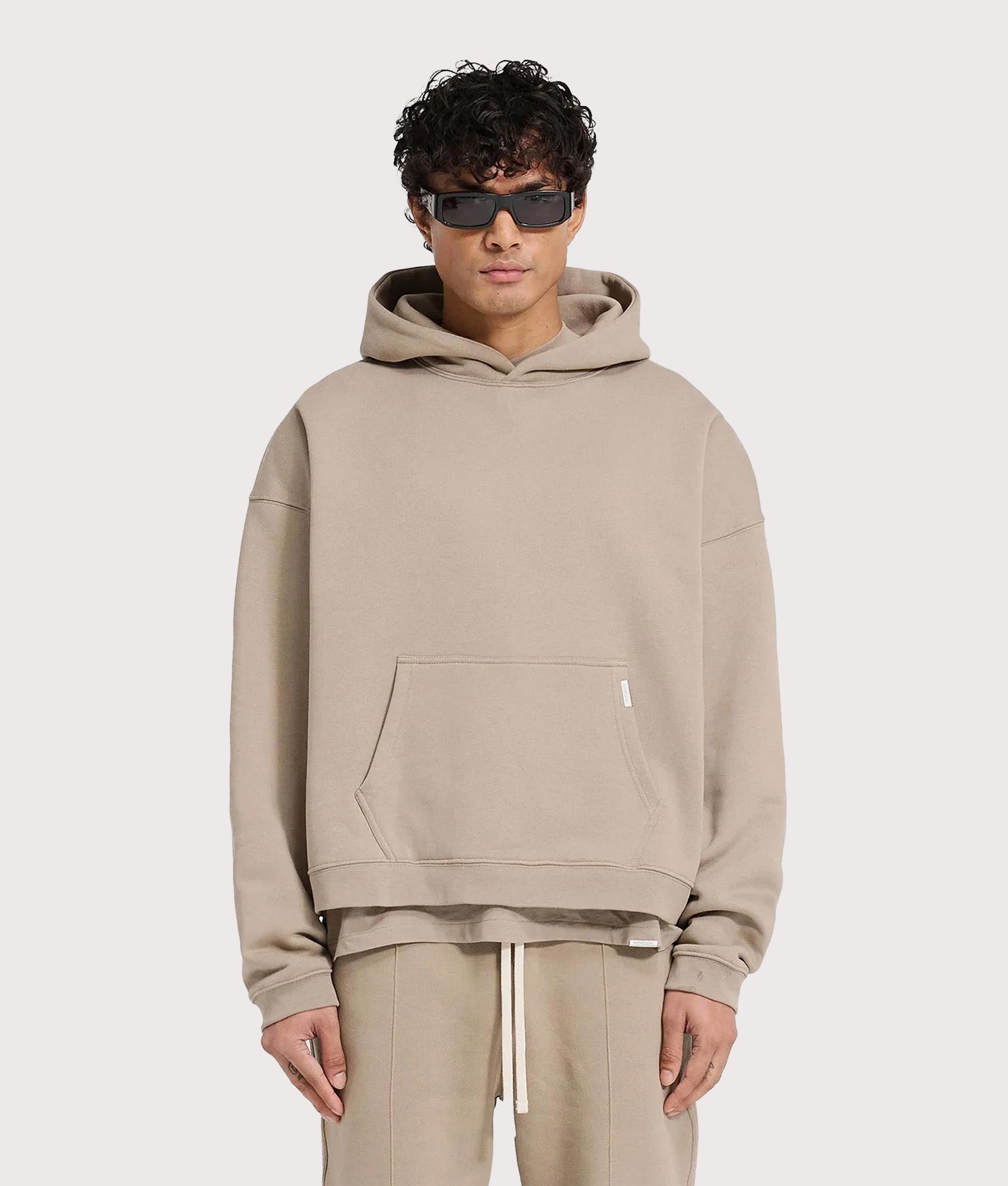 REPRESENT Oversized Initial Boxy Hoodie in Dune at EQVVS Menswear. Model front shot.