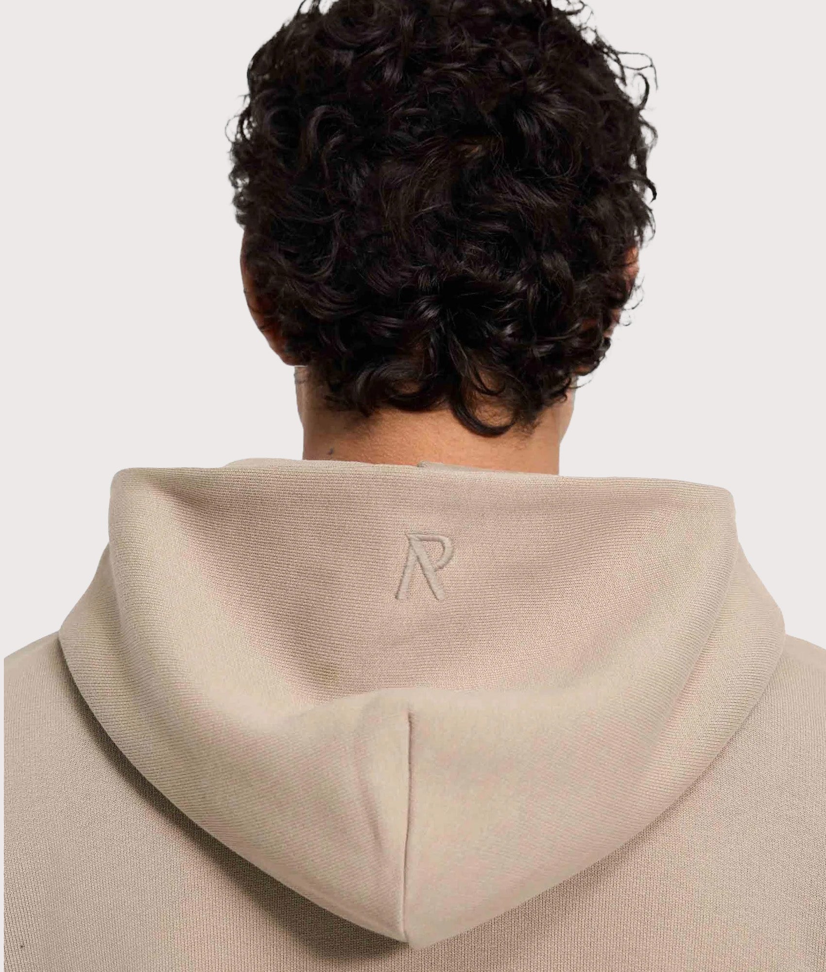 REPRESENT Oversized Initial Boxy Hoodie in Dune at EQVVS Menswear. Detail shot.