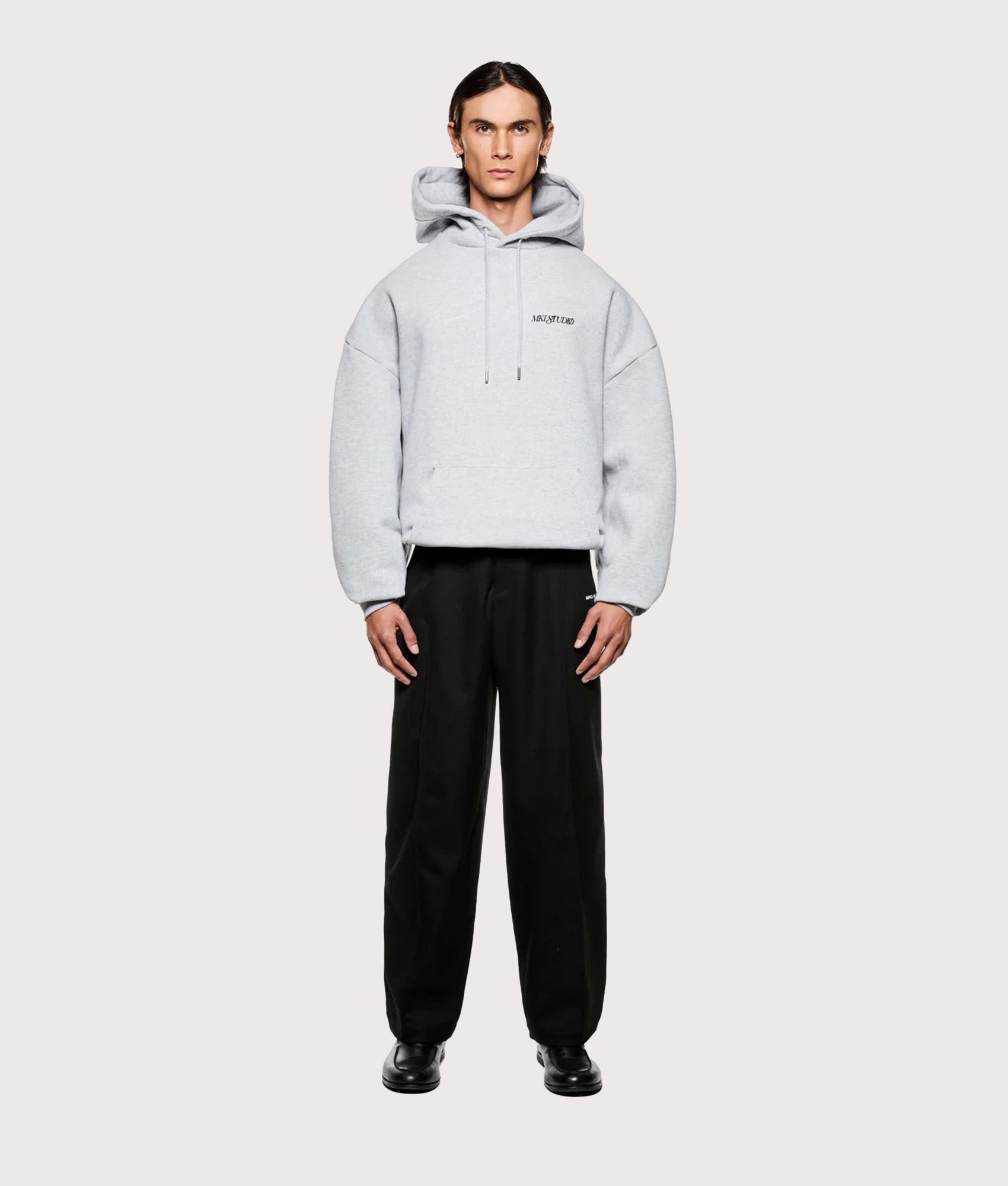 MKI MIYUKI ZOKU Script hoodie in Grey at EQVVS Menswear. Model full front shot.