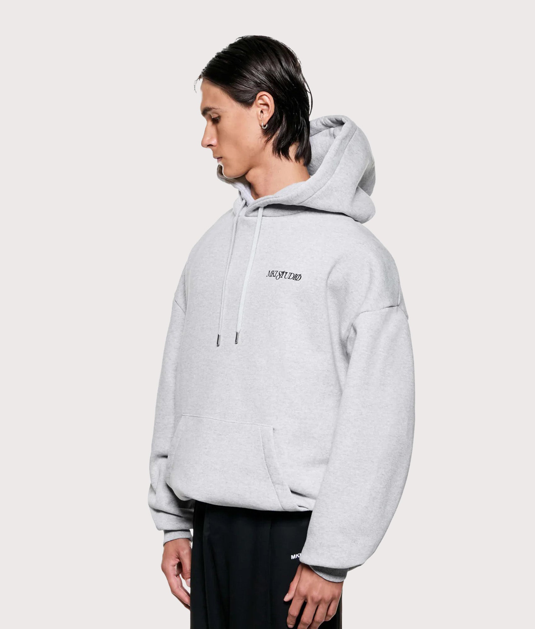 MKI MIYUKI ZOKU Script hoodie in Grey at EQVVS Menswear. Angled model front shot.