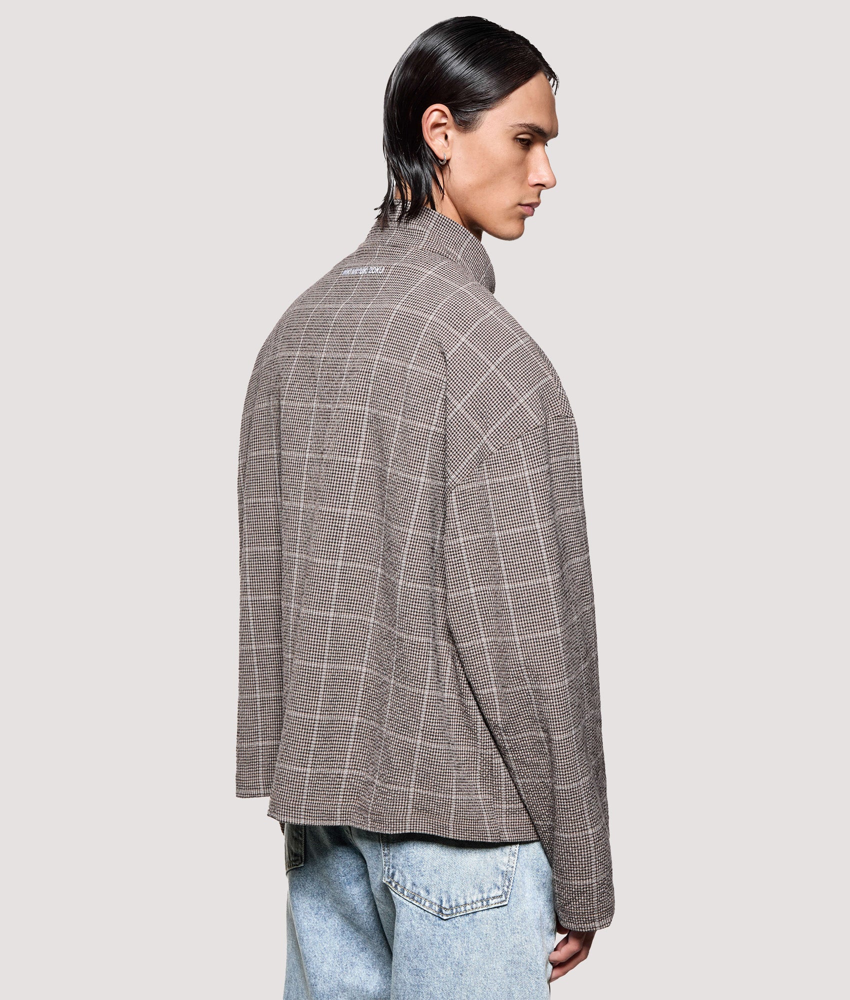 MKI MIYUKI ZOKU Box Fit Seersucker Check Track Jacket in Brown at EQVVS Menswear. Angled model back shot.