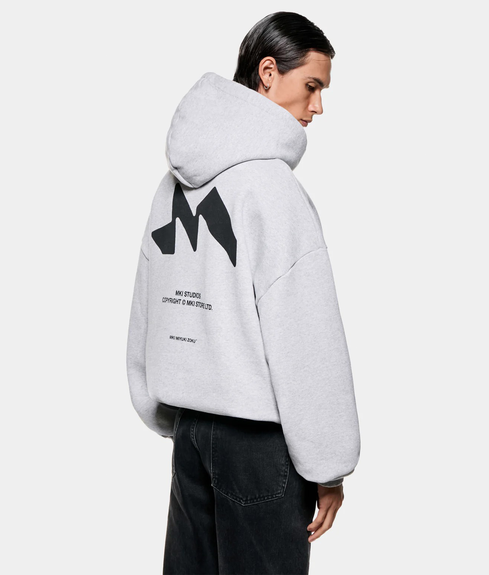 MKI MIYUKI ZOKU Silhouette Hoodie in Grey at EQVVS Menswear. Angled back shot.