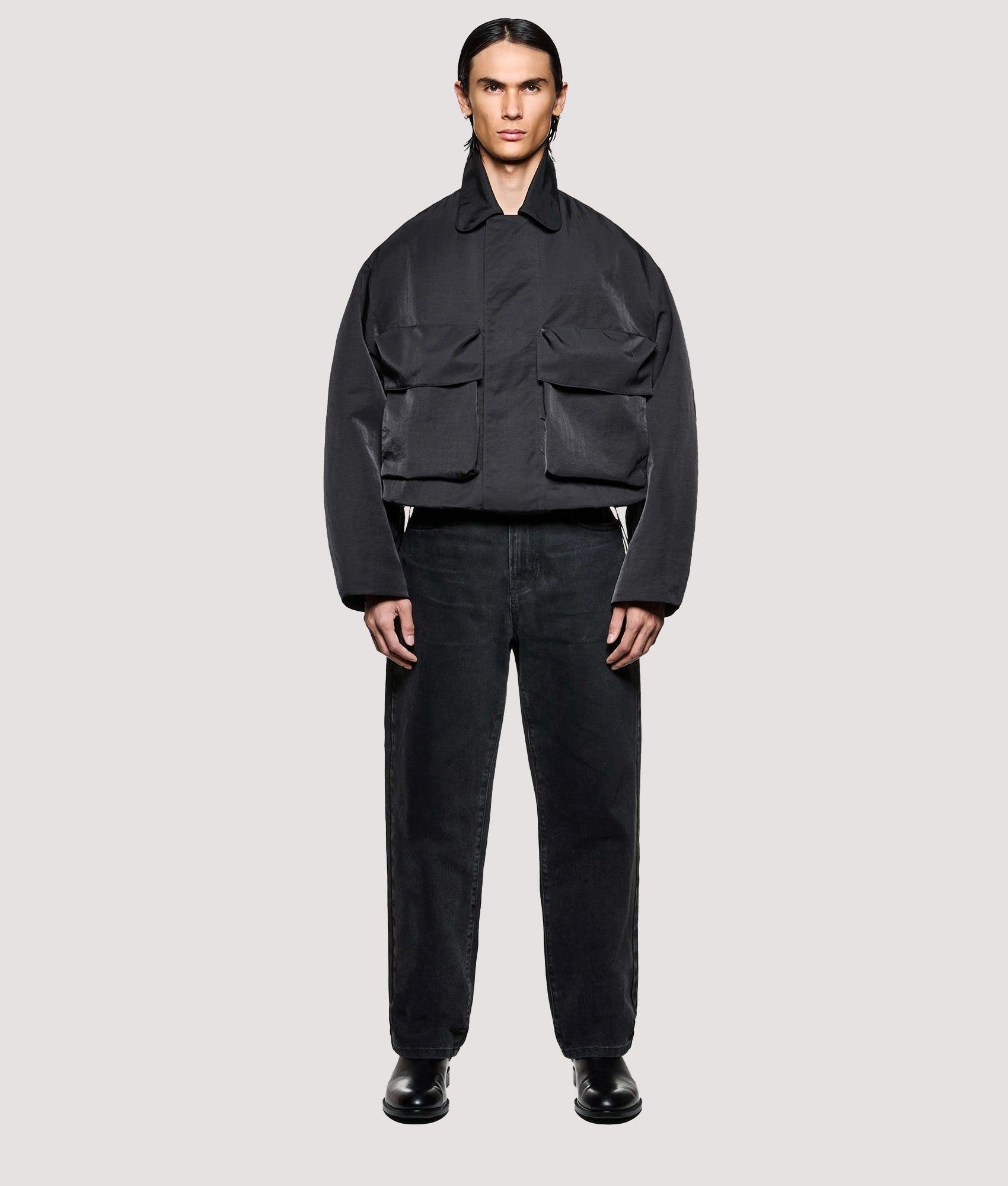 MKI MIYUKI ZOKU Box Fit Silky Nylon Pilot Jacket in Black at EQVVS Menswear. Model full front shot.