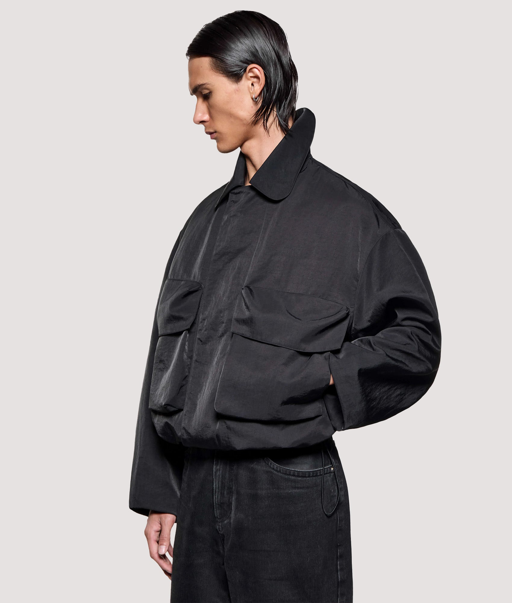MKI MIYUKI ZOKU Box Fit Silky Nylon Pilot Jacket in Black at EQVVS Menswear. Angled model front shot.