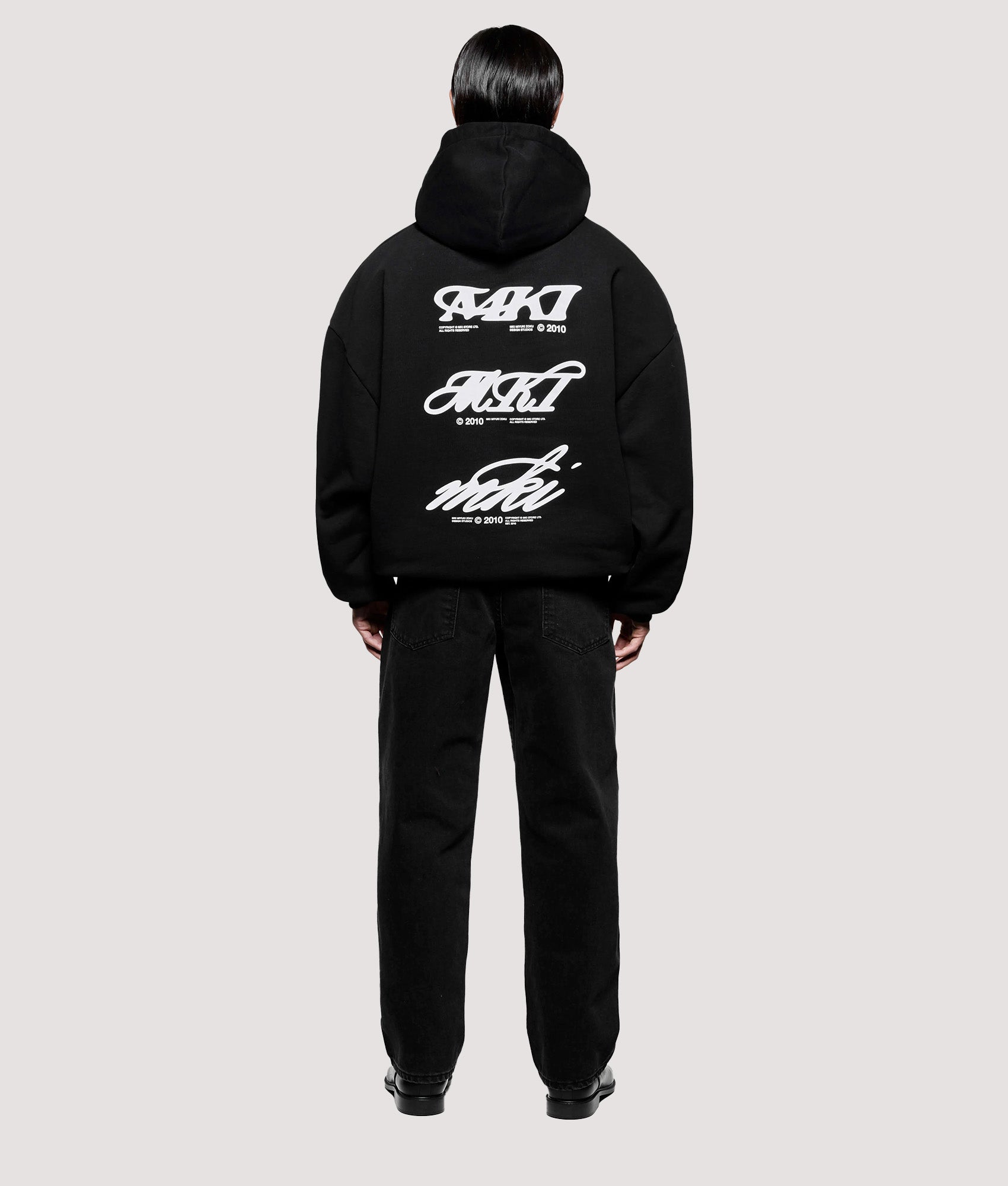 MKI MIYUKI ZOKU Box Fit Stack Hoodie in Black at EQVVS Menswear. Model back shot.