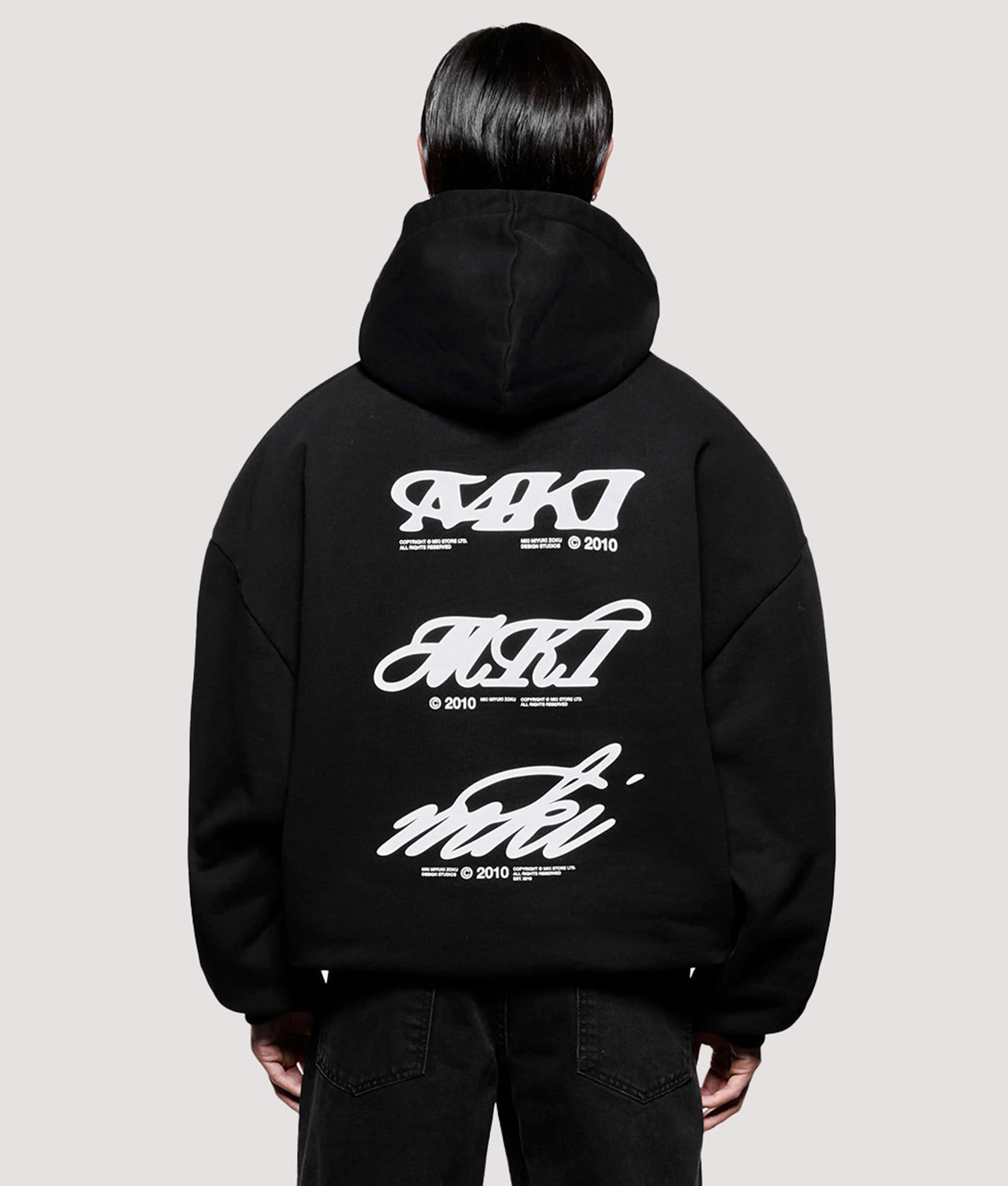 MKI MIYUKI ZOKU Box Fit Stack Hoodie in Black at EQVVS Menswear. Model back shot.