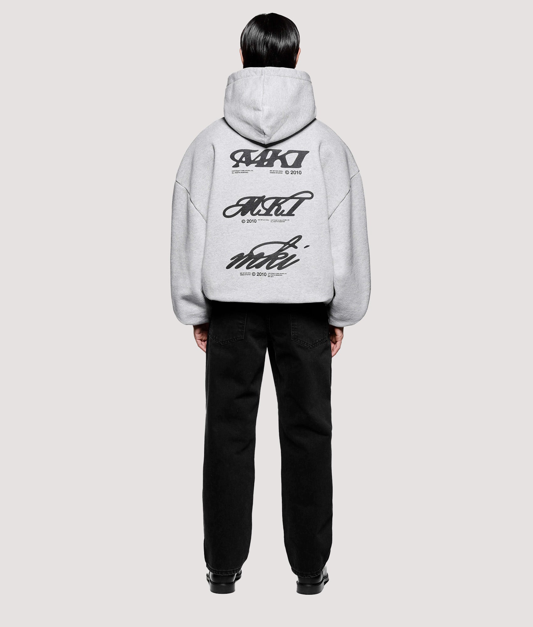 MKI MIYUKI ZOKU Box Fit Stack Hoodie in Grey at EQVVS Menswear. Model full back shot.