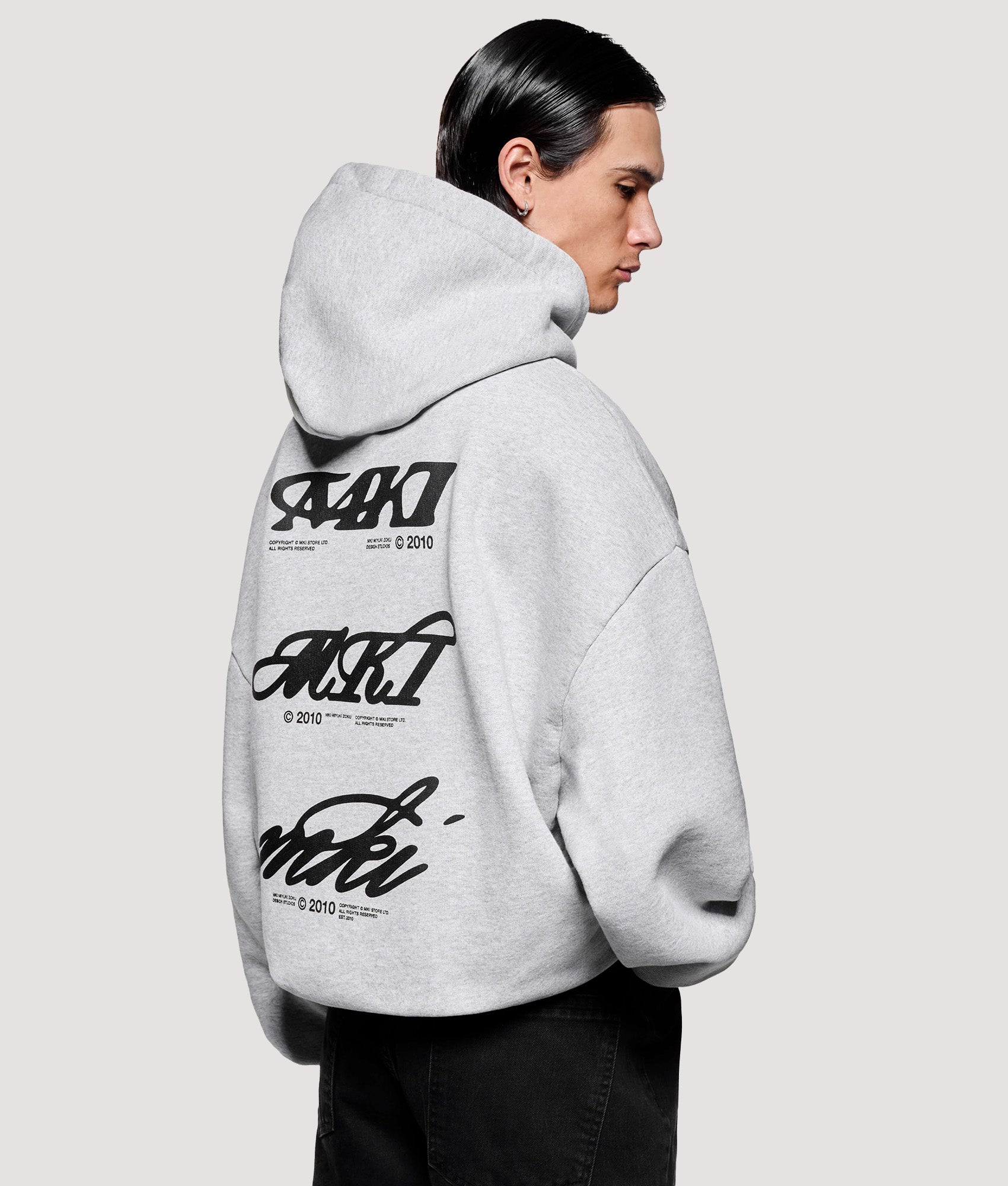 MKI MIYUKI ZOKU Box Fit Stack Hoodie in Grey at EQVVS Menswear. Angled model back shot.